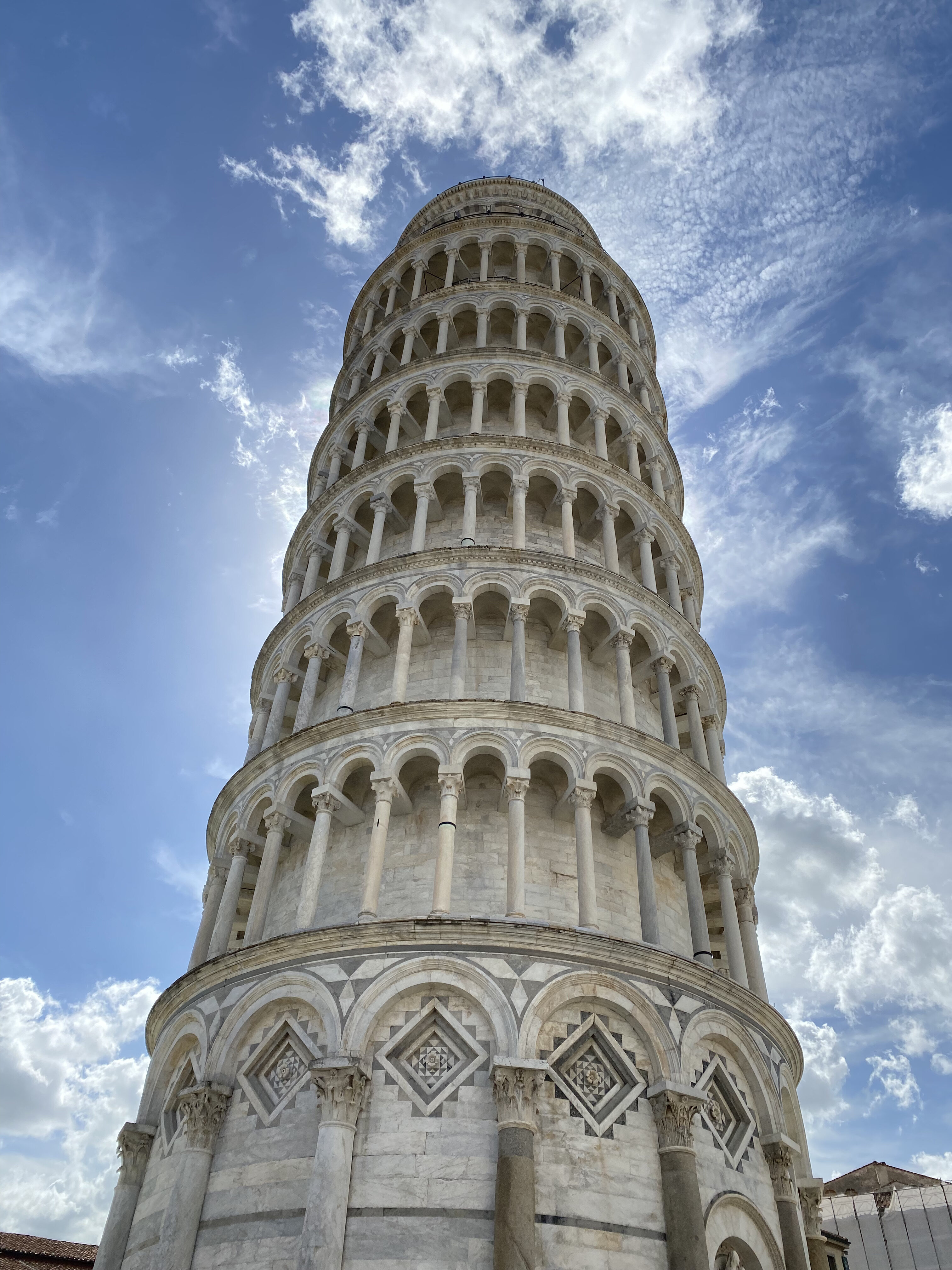 The Leaning Tower of Pisa in front of a bright blue sky.