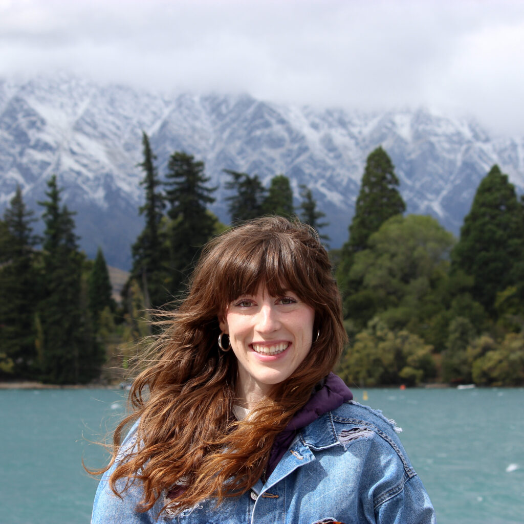 Bella stands in front of the Remarkables in Queenstown, New Zealand.