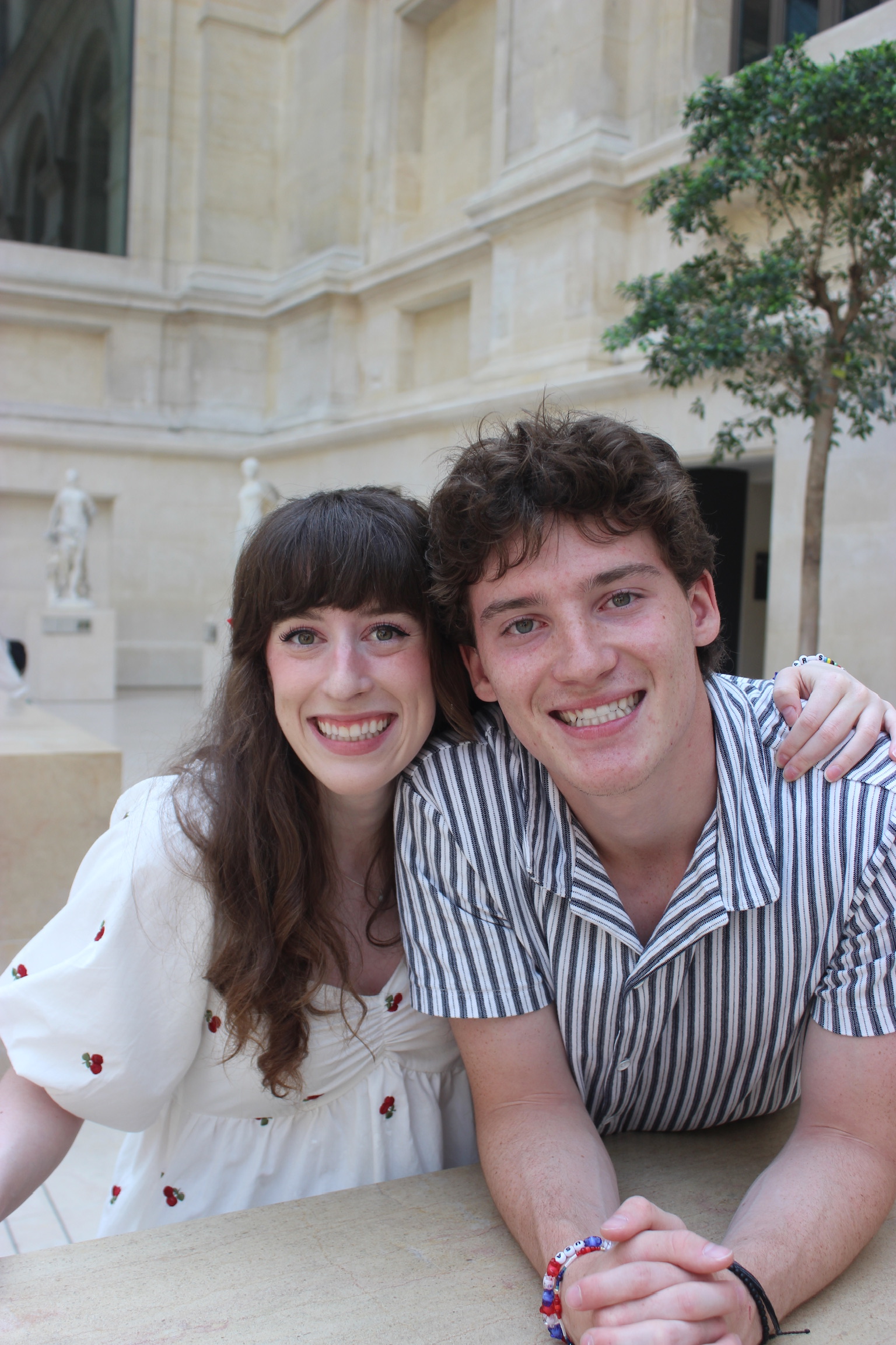 Bella and her brother Liam smiling together in the Louvre.