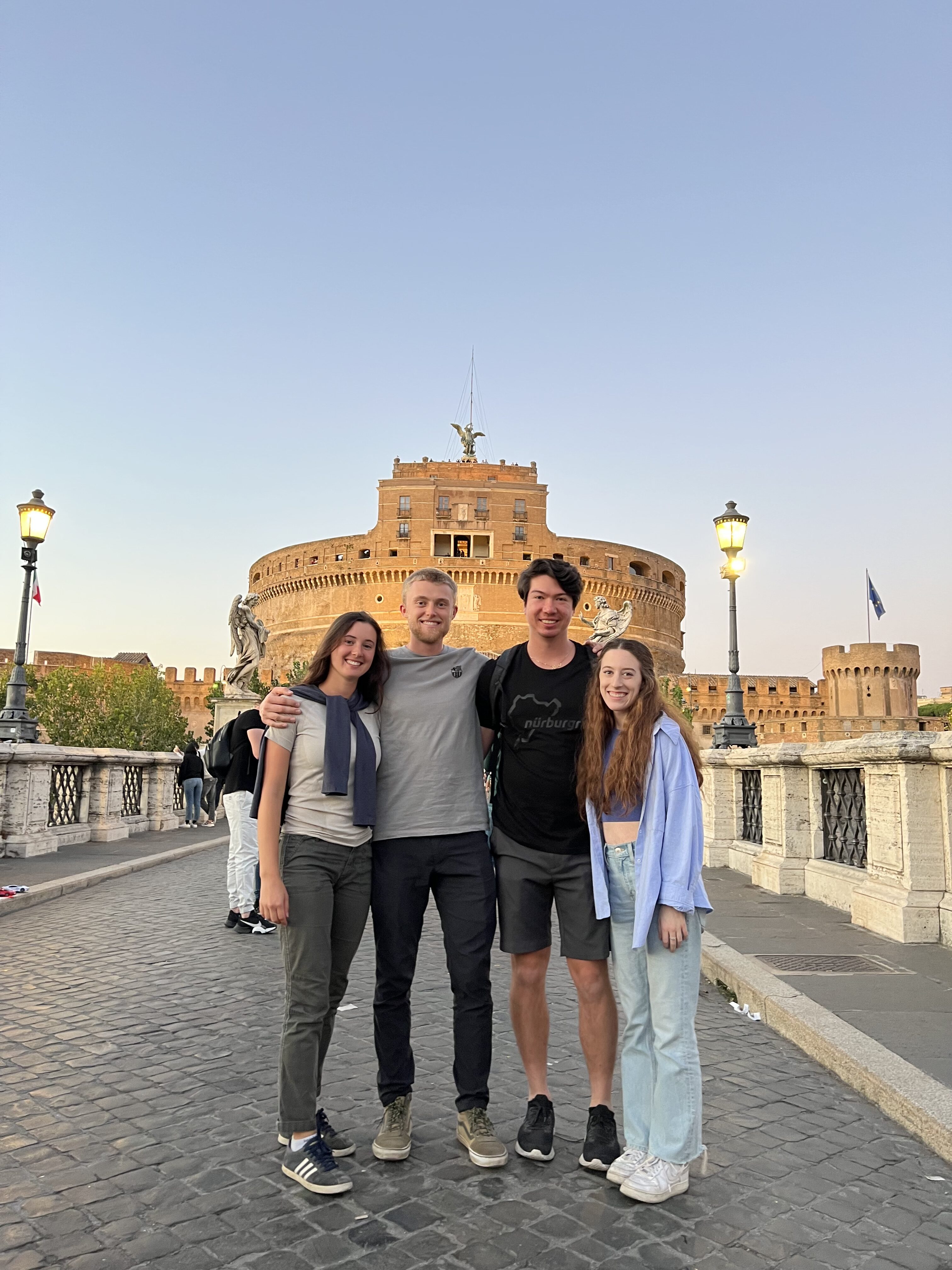 Rome is better with friends! Four people posing for a group picture in front of the Castel Sant'Angelo monument in Rome, Italy.