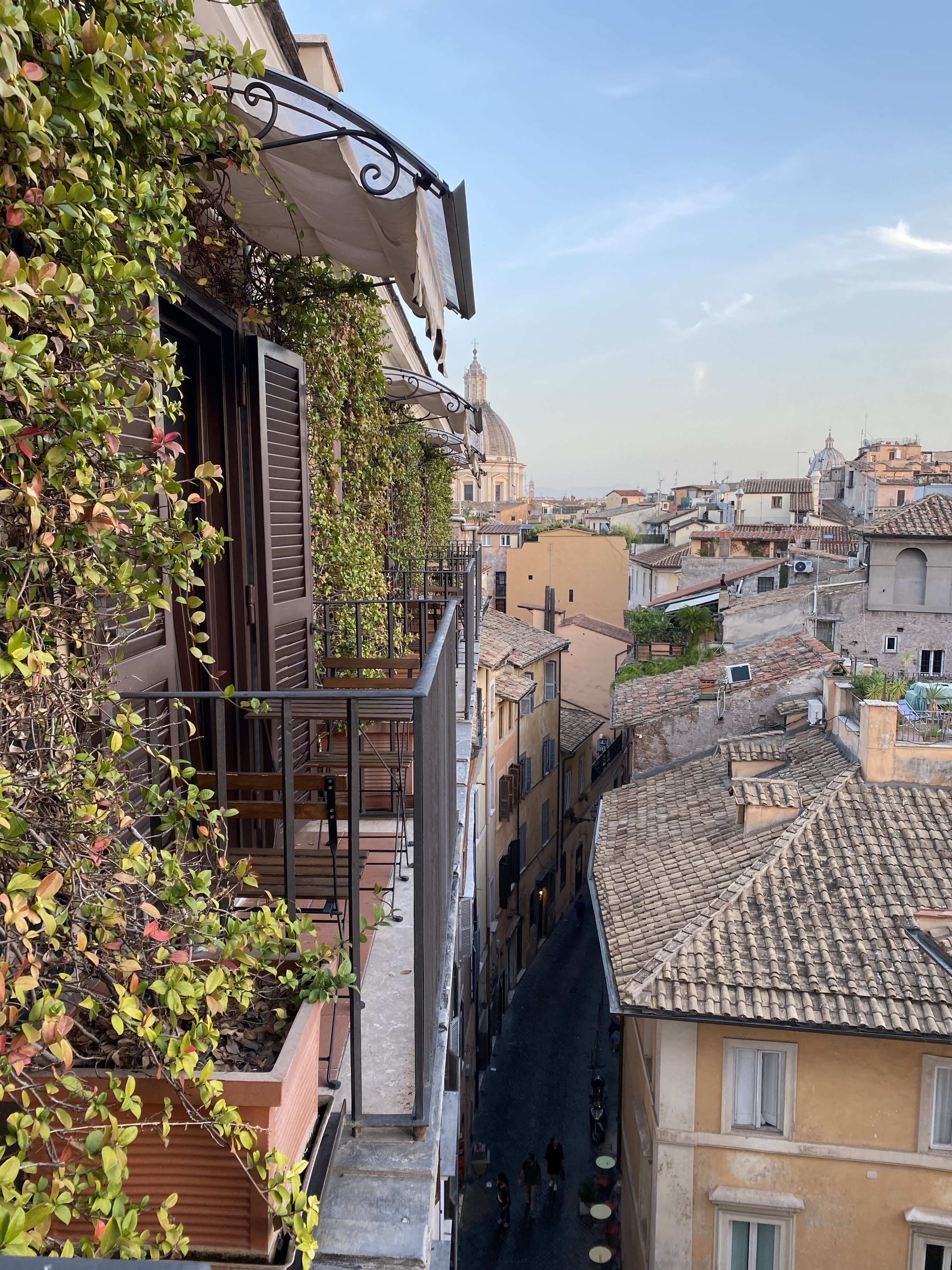 View from a balcony at Terrazze Navona hotel overlooking the rooftops of Rome, with St. Agnes in Agone dome in the distance.