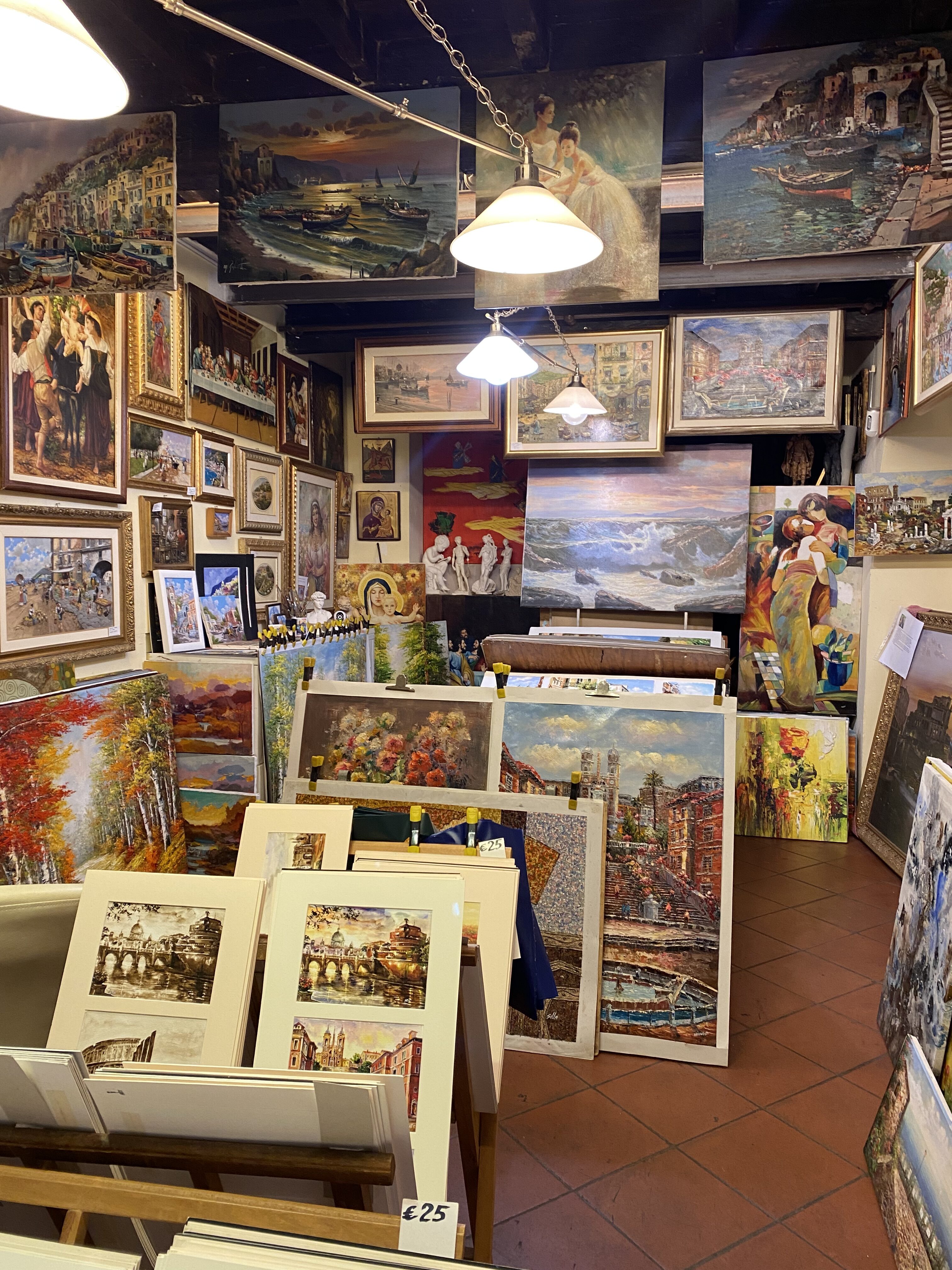 A small, local Roman gallery decorate with paintings and prints of scenes of life in Rome.
