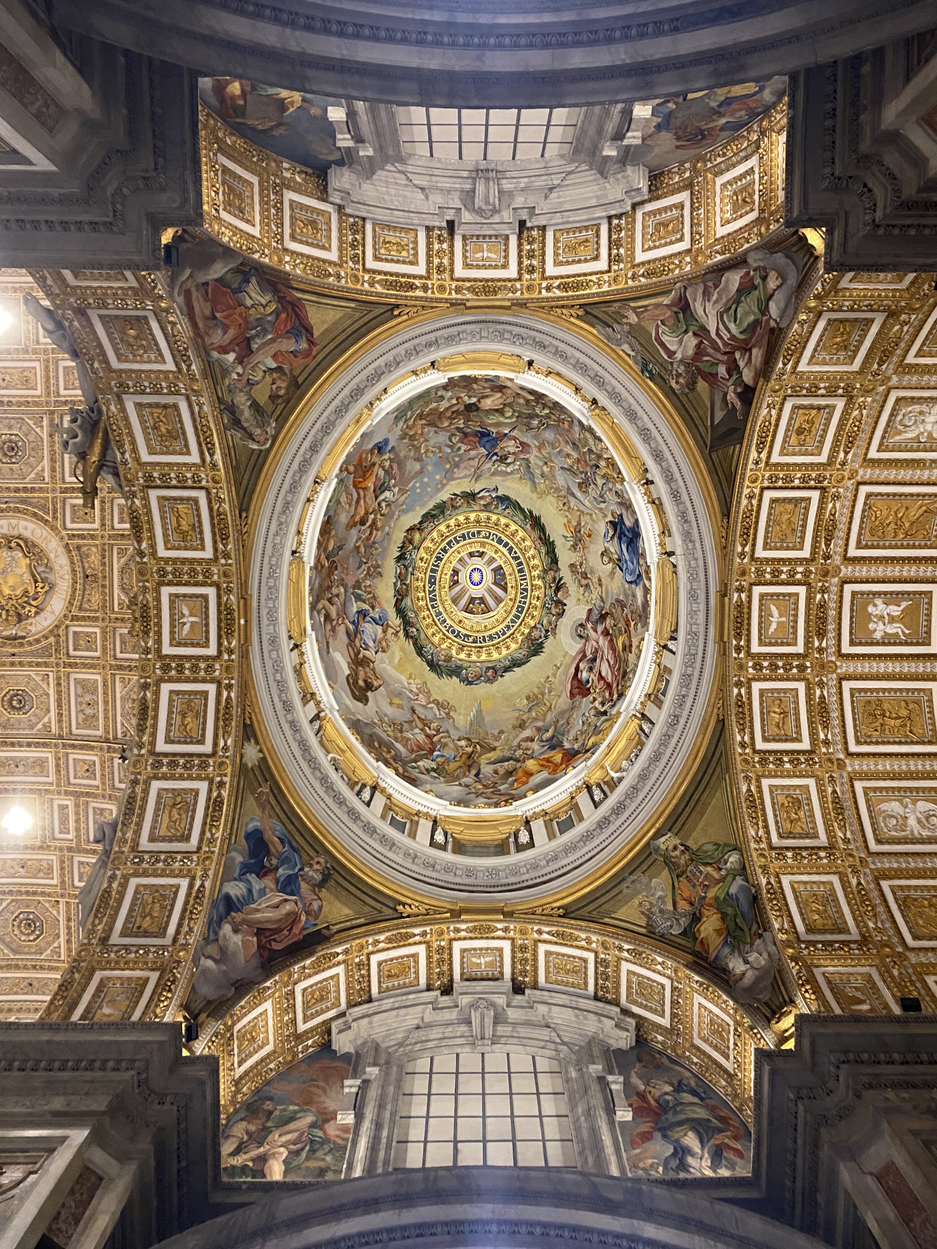 Make sure to look up when you visit St. Peter's Basilica! The ceiling is incredible! A view of the ornate golden ceiling or St. Peter's Basilica from beneath the painted ceiling of the basilica's dome.