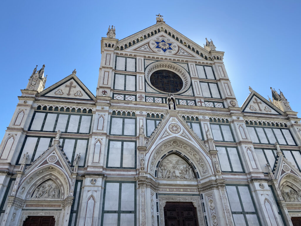 The stunning white, green and red stone facade of Basilica di Santa Croce in Florence, Italy.