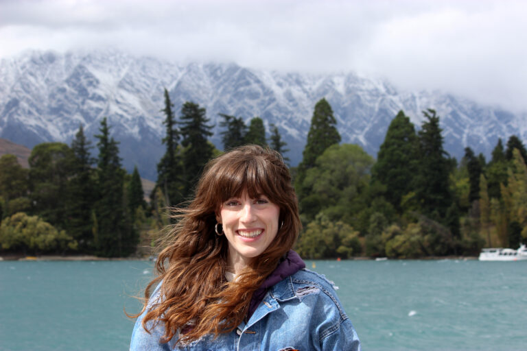 Bella standing in front of the beautiful New Zealand mountain range called the Remarkables.