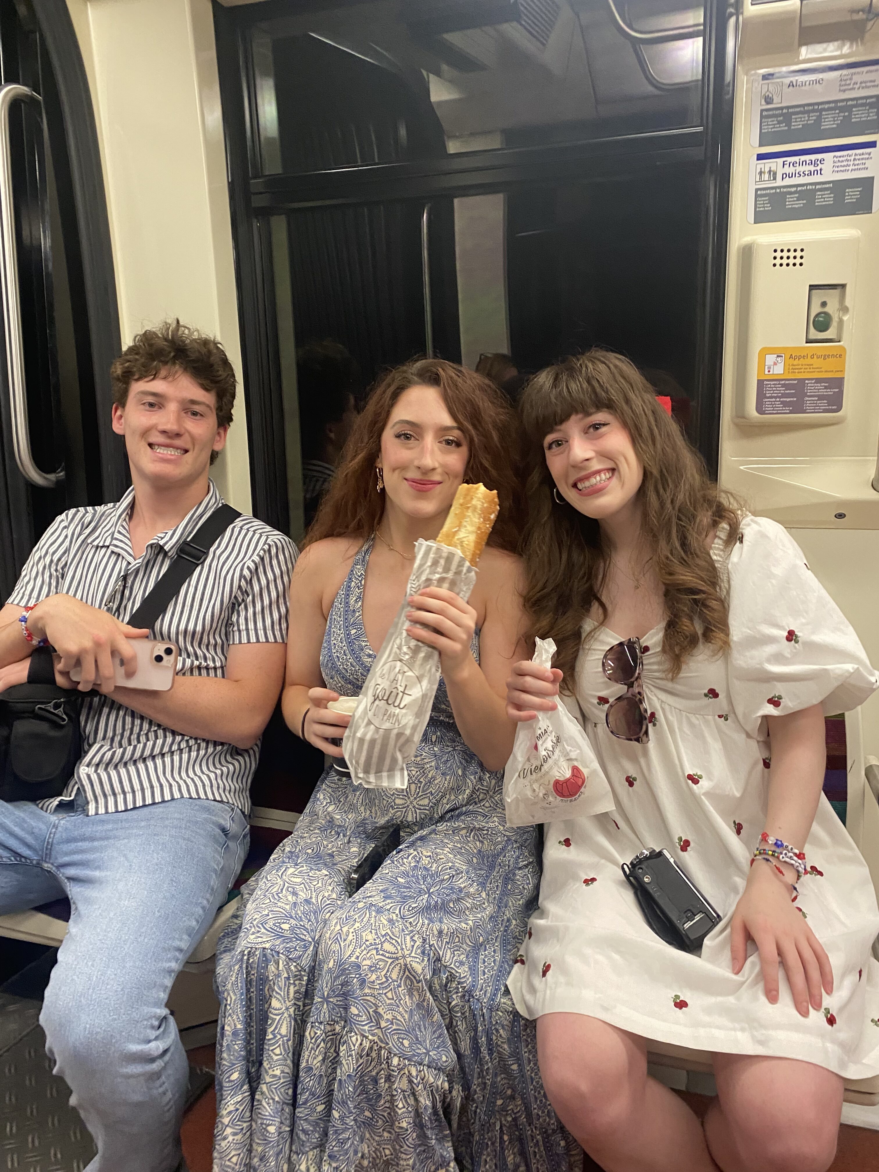 Bella with Lily and Liam (twin sister and brother) on the Paris Metro. Lily is holding a baguette.