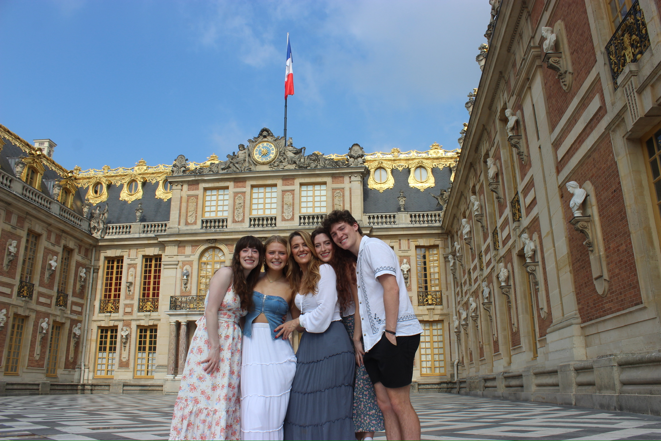 The Allen Family (left to right: Bella, Sophia, Mom, Lily and Liam) standing in front of the Palace of Versailles