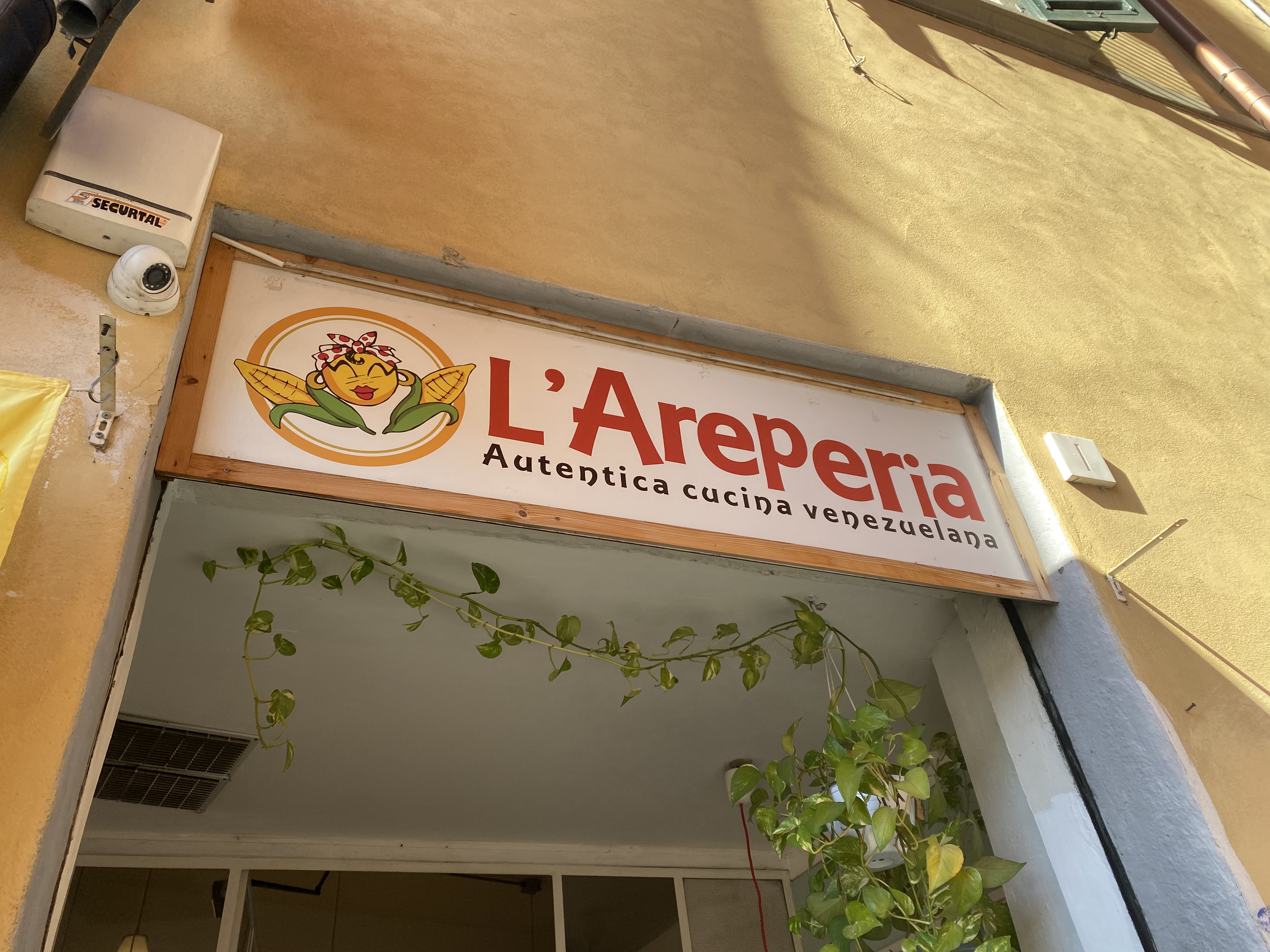 A yellow building in Florence with a sign that reads, "L'Areperia".