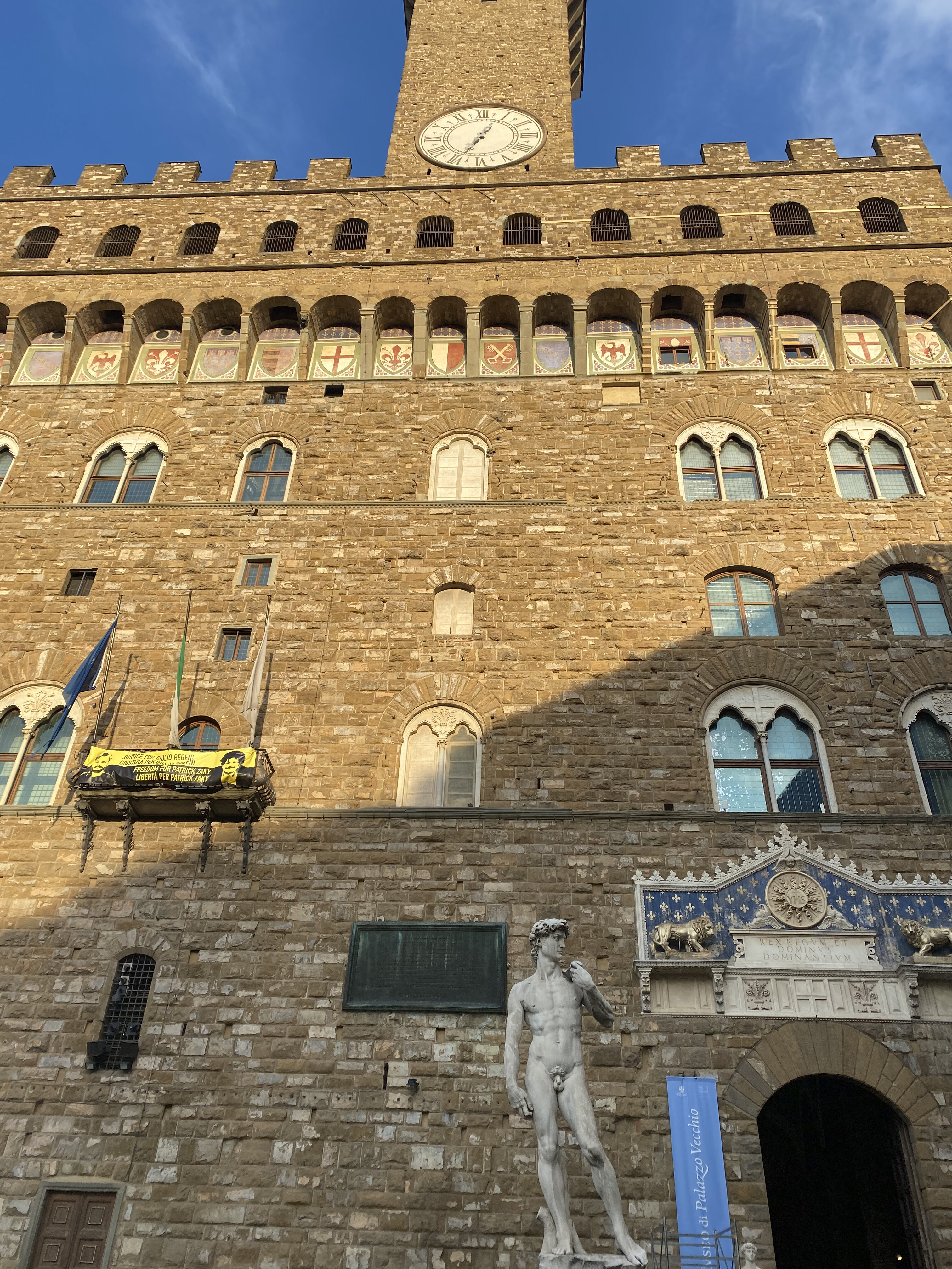 The front facade of Palazzo Vecchio, with the David replica erected outside the entrance.