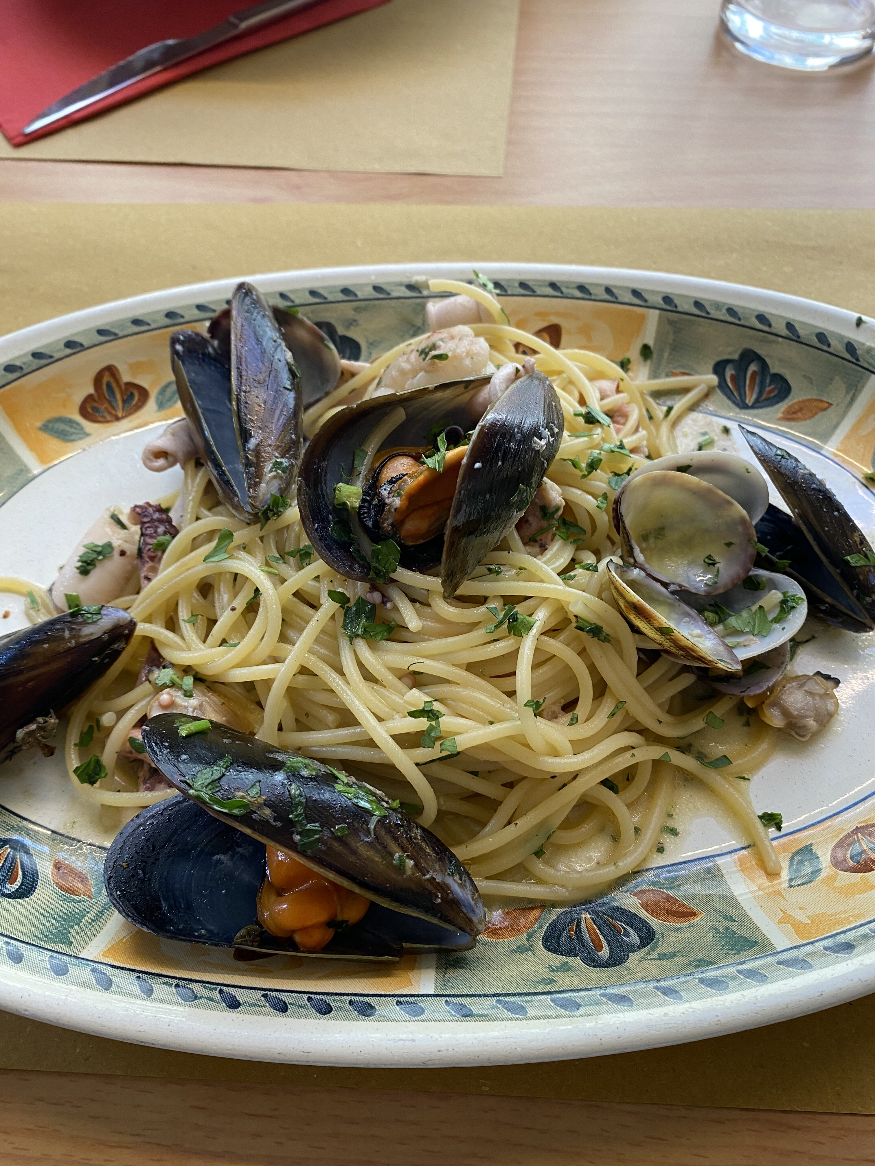 A plate of buttery spaghetti with clams and mussels, a traditional Italian dish called "spaghetti allo scoglio".