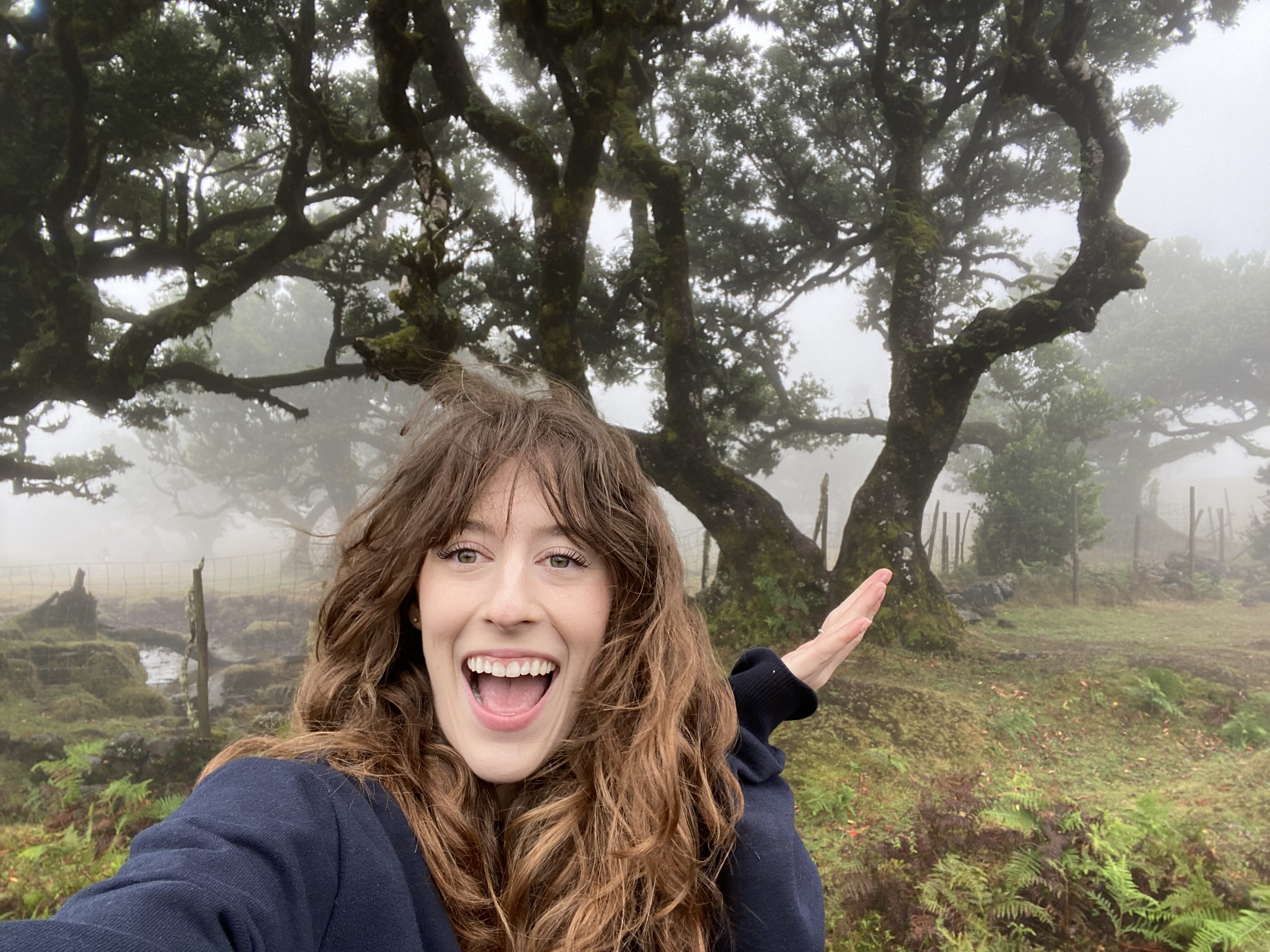 Bella posing in front of the mystical Fanal Forest in Madeira, featuring a foggy background with eerie Laurissilva trees.