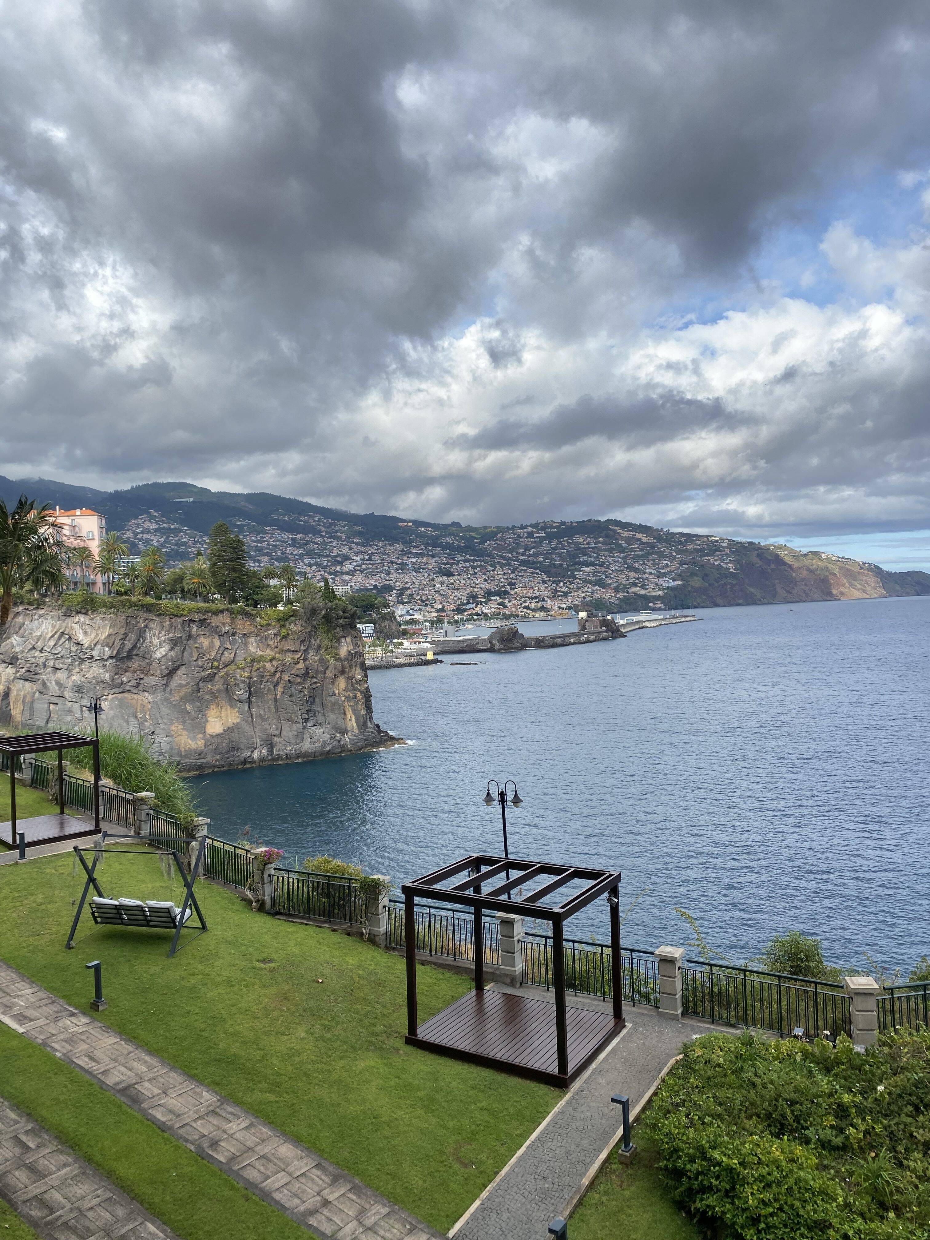 Cliff Bay hotel lawn with a beautiful view of the cliff of São Martinho and the city of Funchal in the distance.