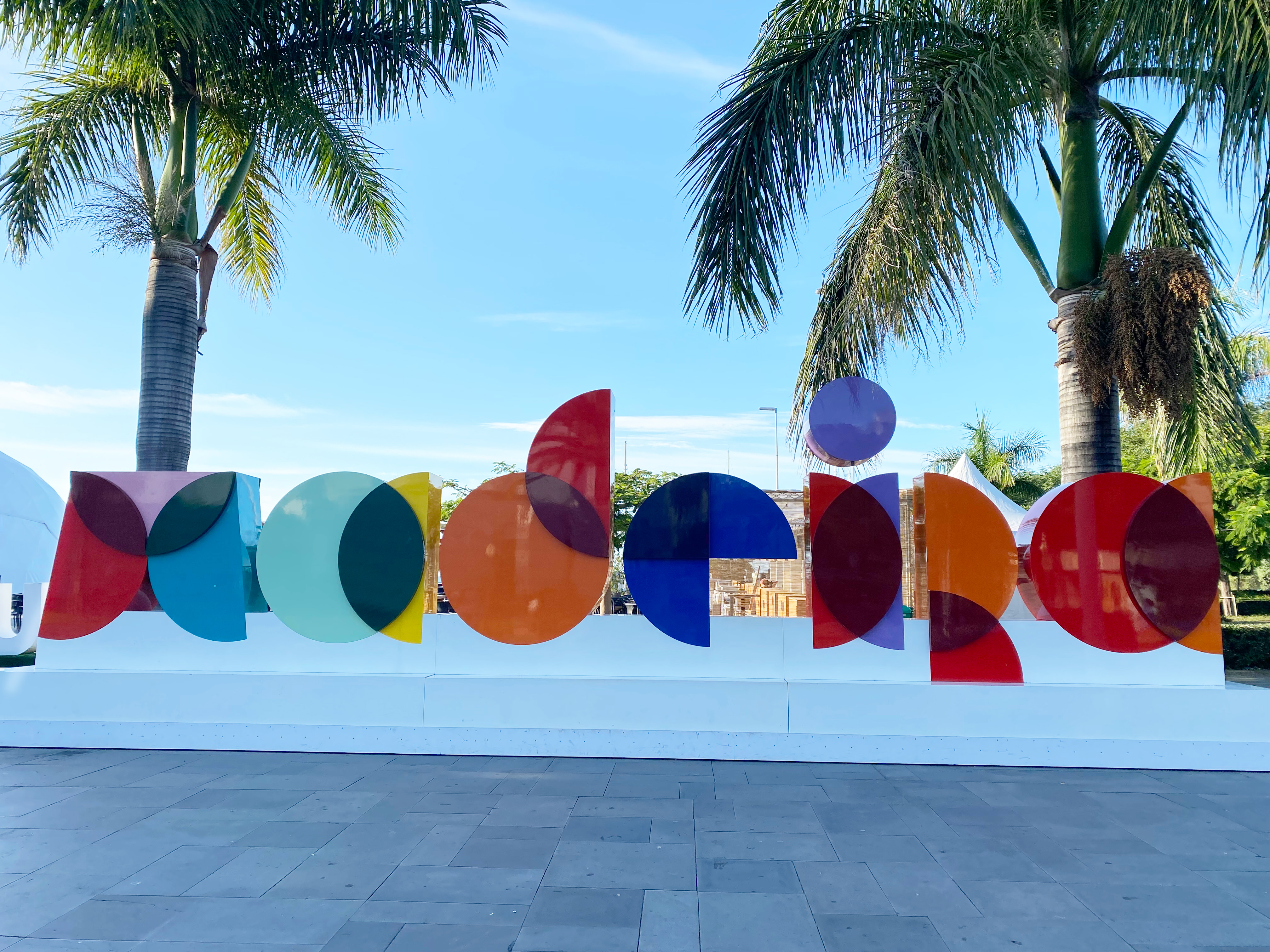 A geometric, colorful city sign that reads, "Madeira", with palm trees in the background.