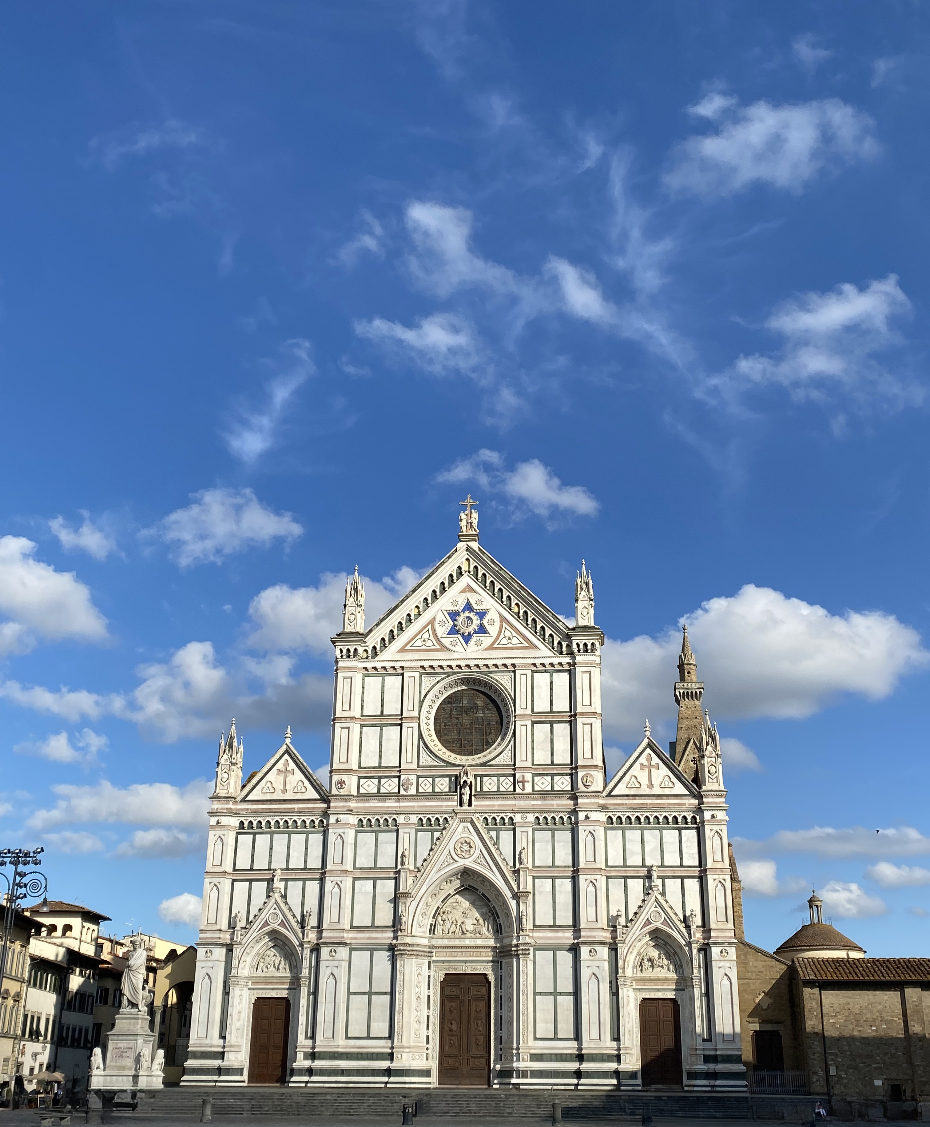 The beautiful Santa Croce Basilica inspired by Italian Gothic architecture. A vibrant, cloudy blue sky frames the large basilica.