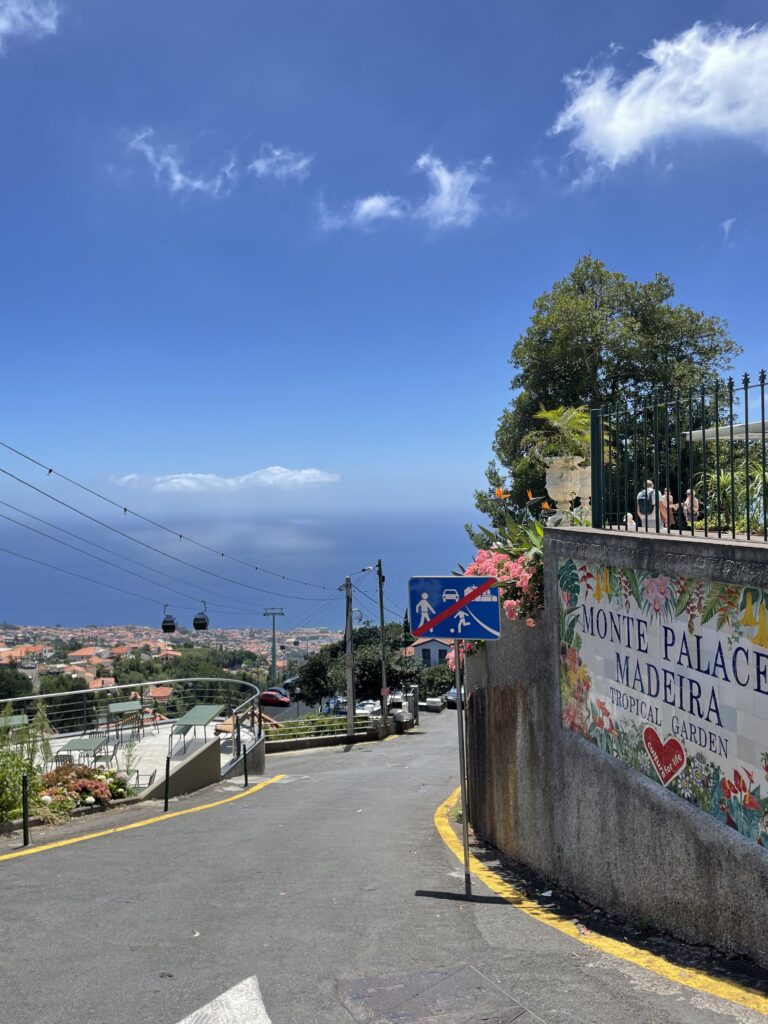 View of the North Atlantic Ocean and a Monte Palace Tropical Garden sign at the top of Funchal.