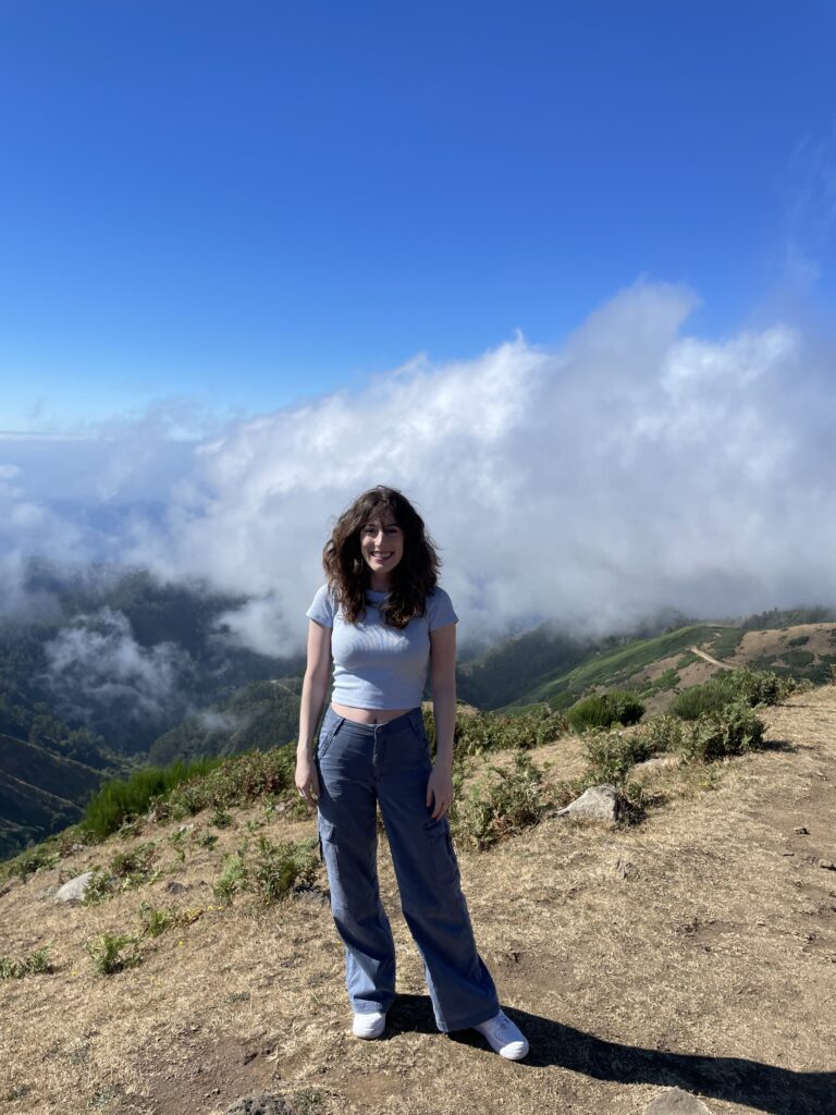 Bella posing at the Lombo do Mouro Viewpoint with clouds rolling in.