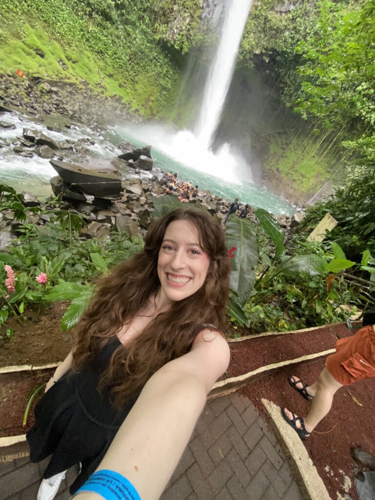 Bella taking a selfie in front of La Fortuna Waterfall.