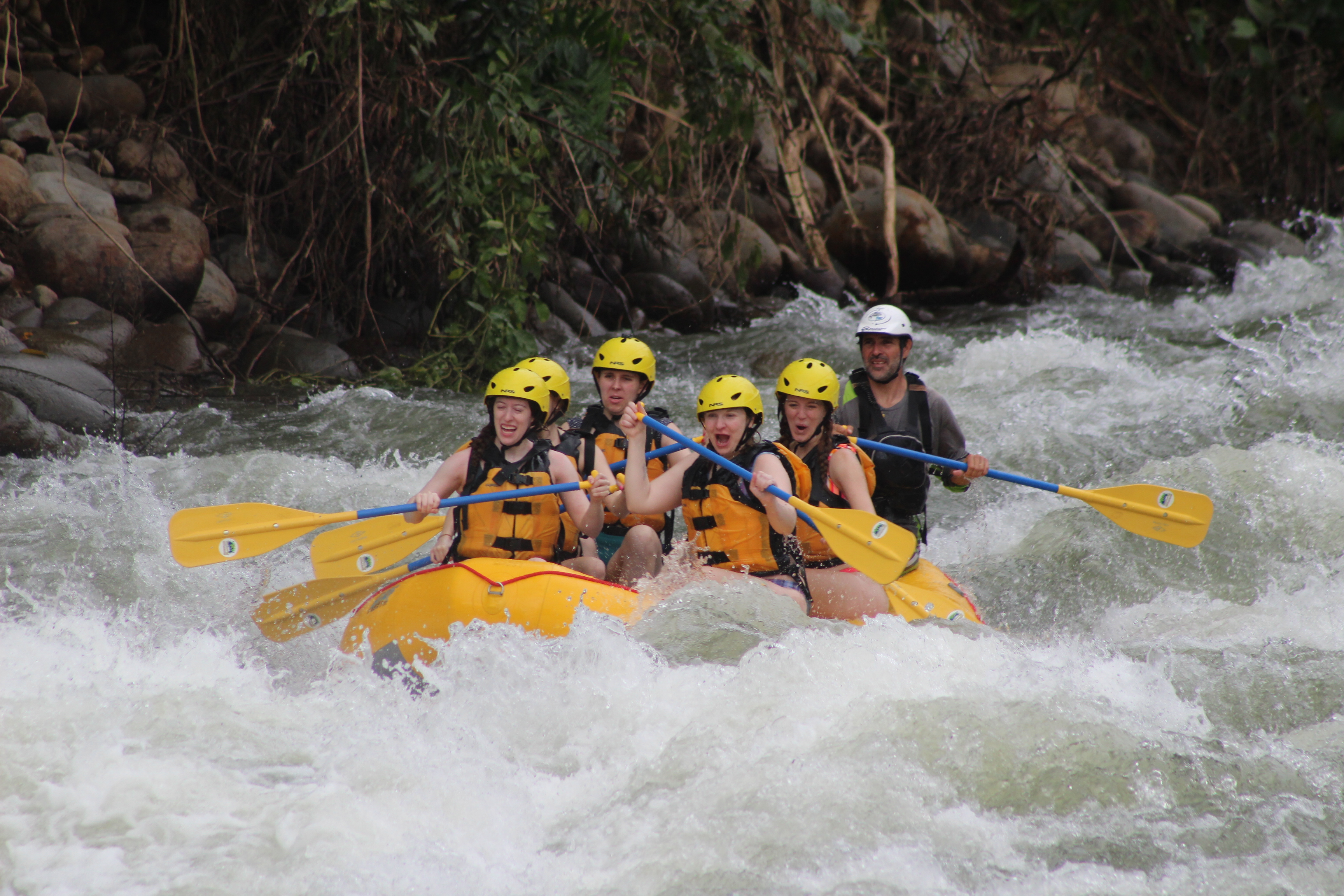 A group of young girls whitewater rafting on the Sarapiqui River with their Costa Rican guide.