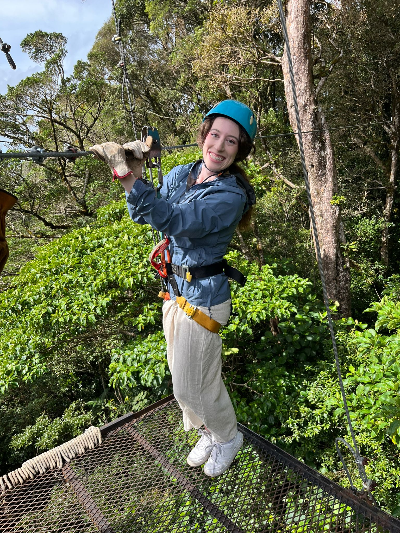 Bella holding onto the zip-line before journeying across the treetops.