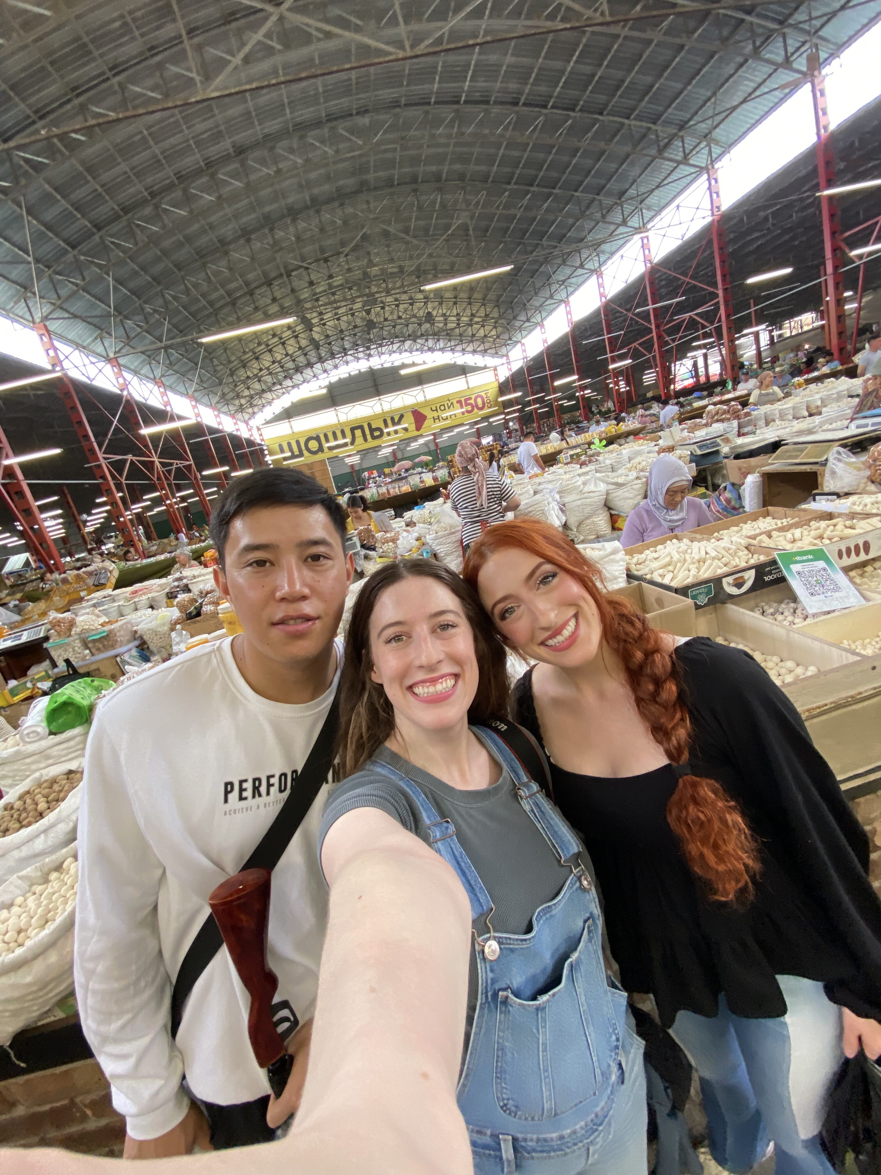 A selfie of Bella and Lily with a local Kyrgyz friend (Suiunbek) at the Osh Bazaar.