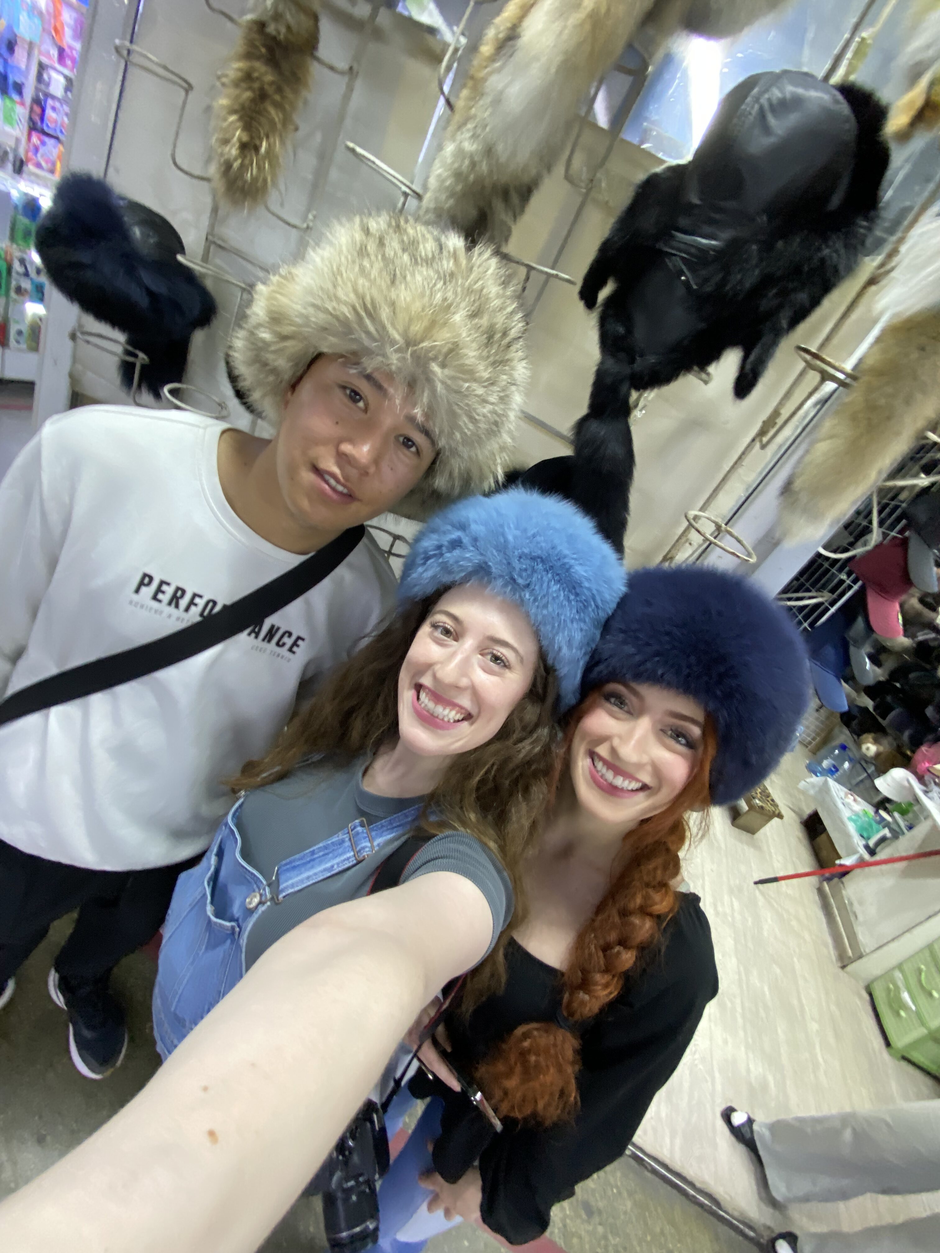 Three people wearing fluffy Kyrgyz hats.