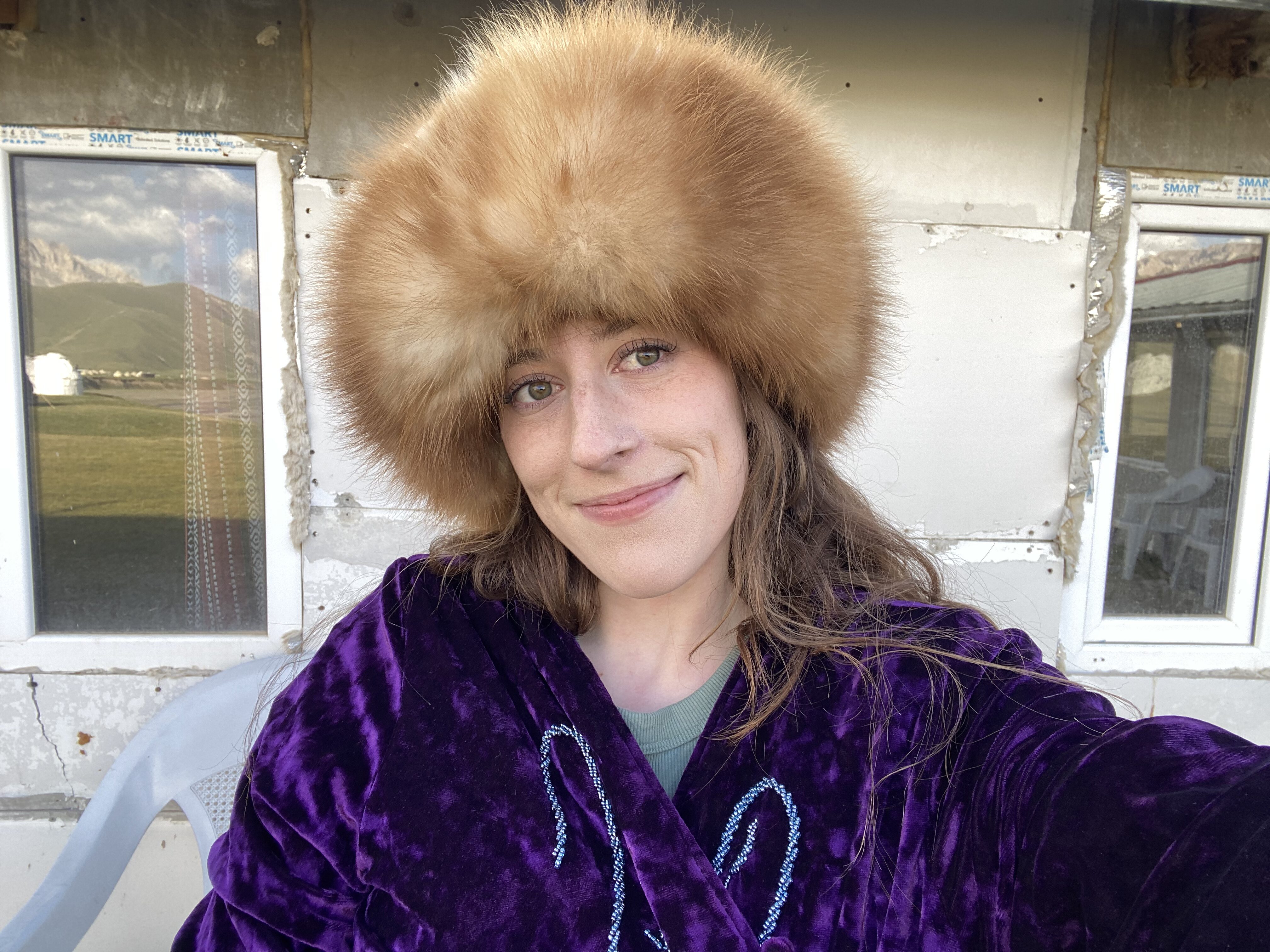 Bella, taking a selfie in a purple coat and a brown, fluffy fur hat.