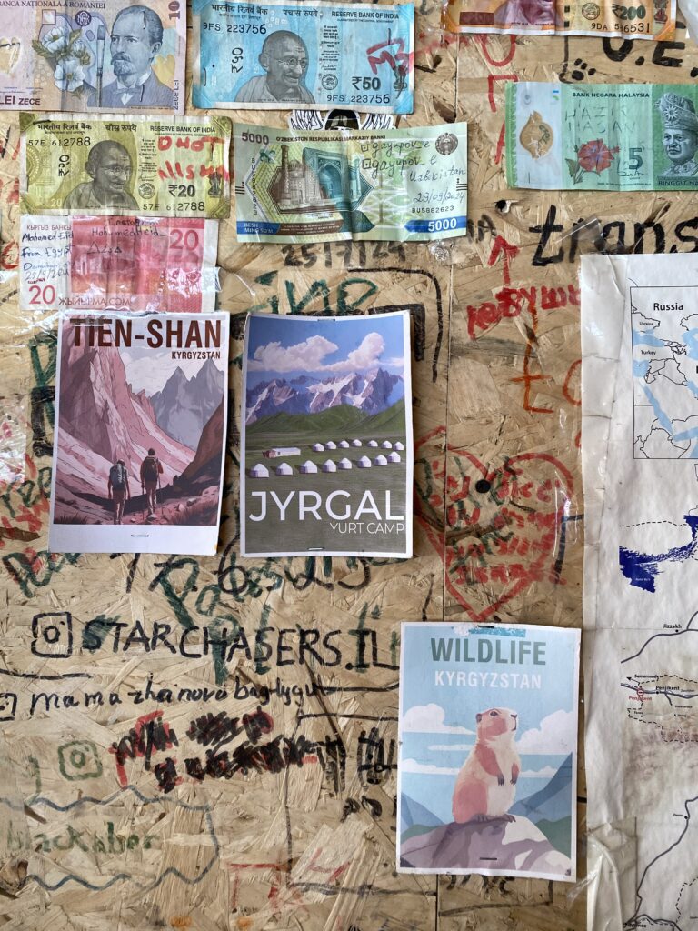 A decorated wooden wall with international currency, signatures and postcards.