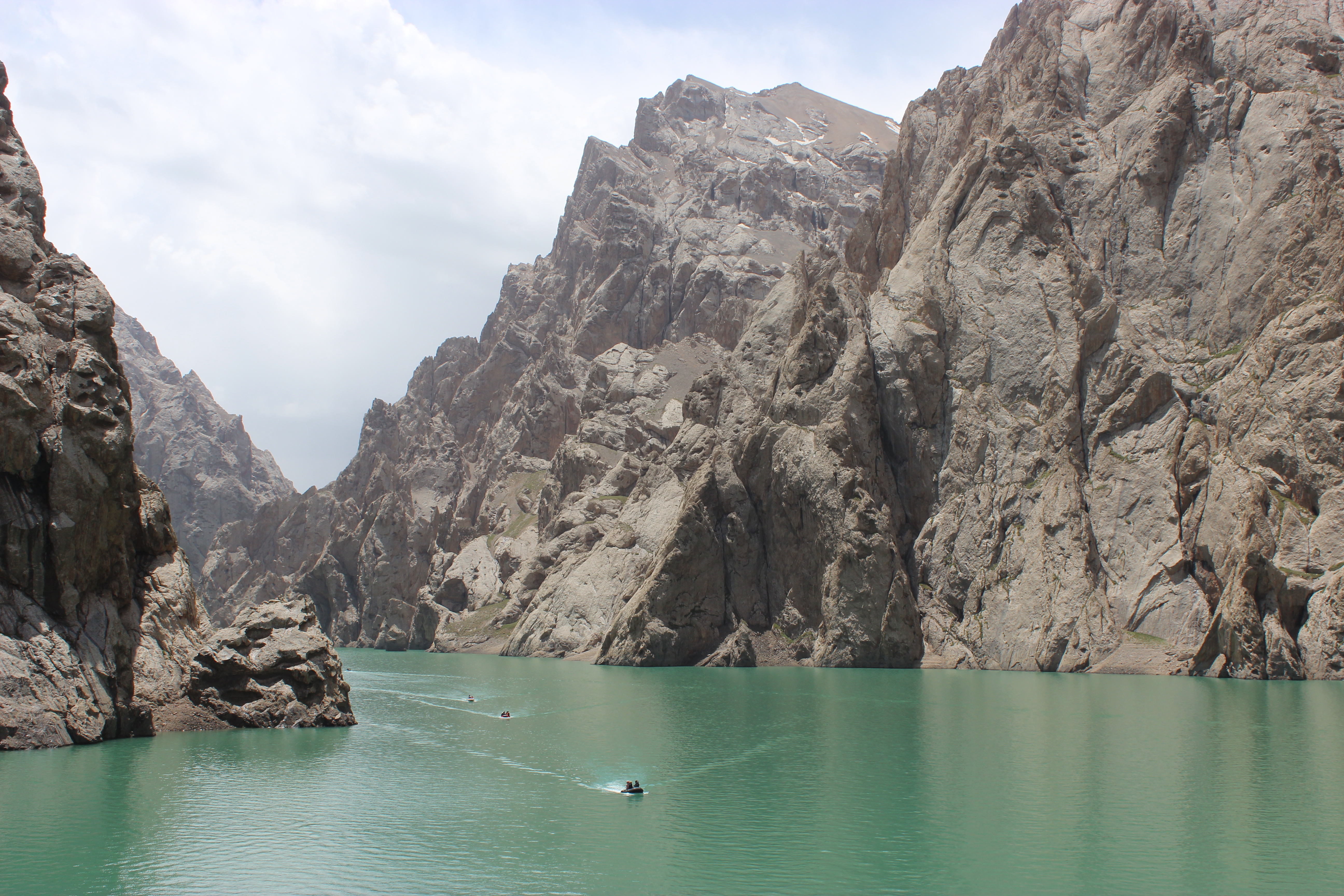 Kel Suu lake, with a small boat in the center.