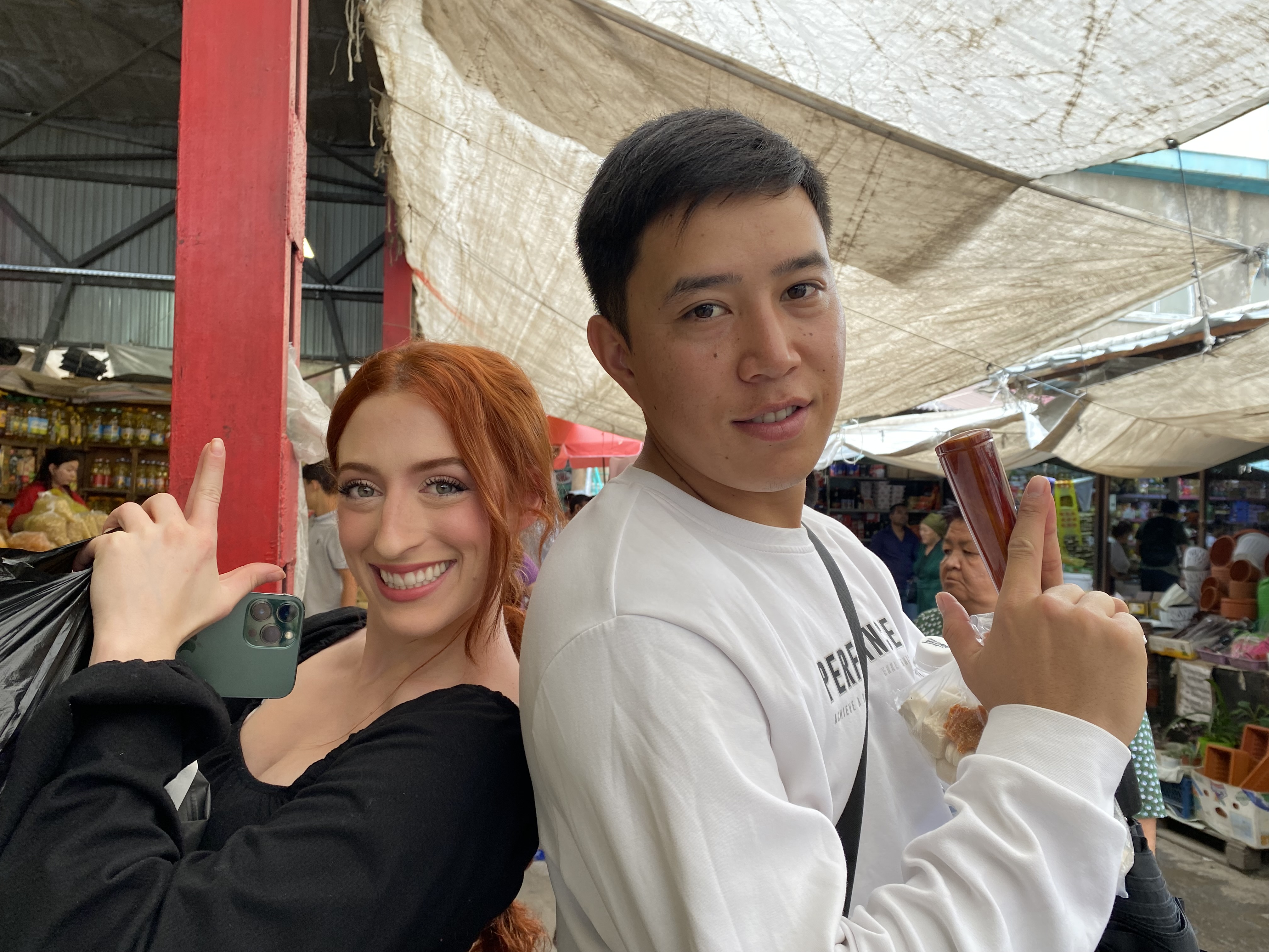Lily and Suiunbek posing with "finger guns" for the camera.