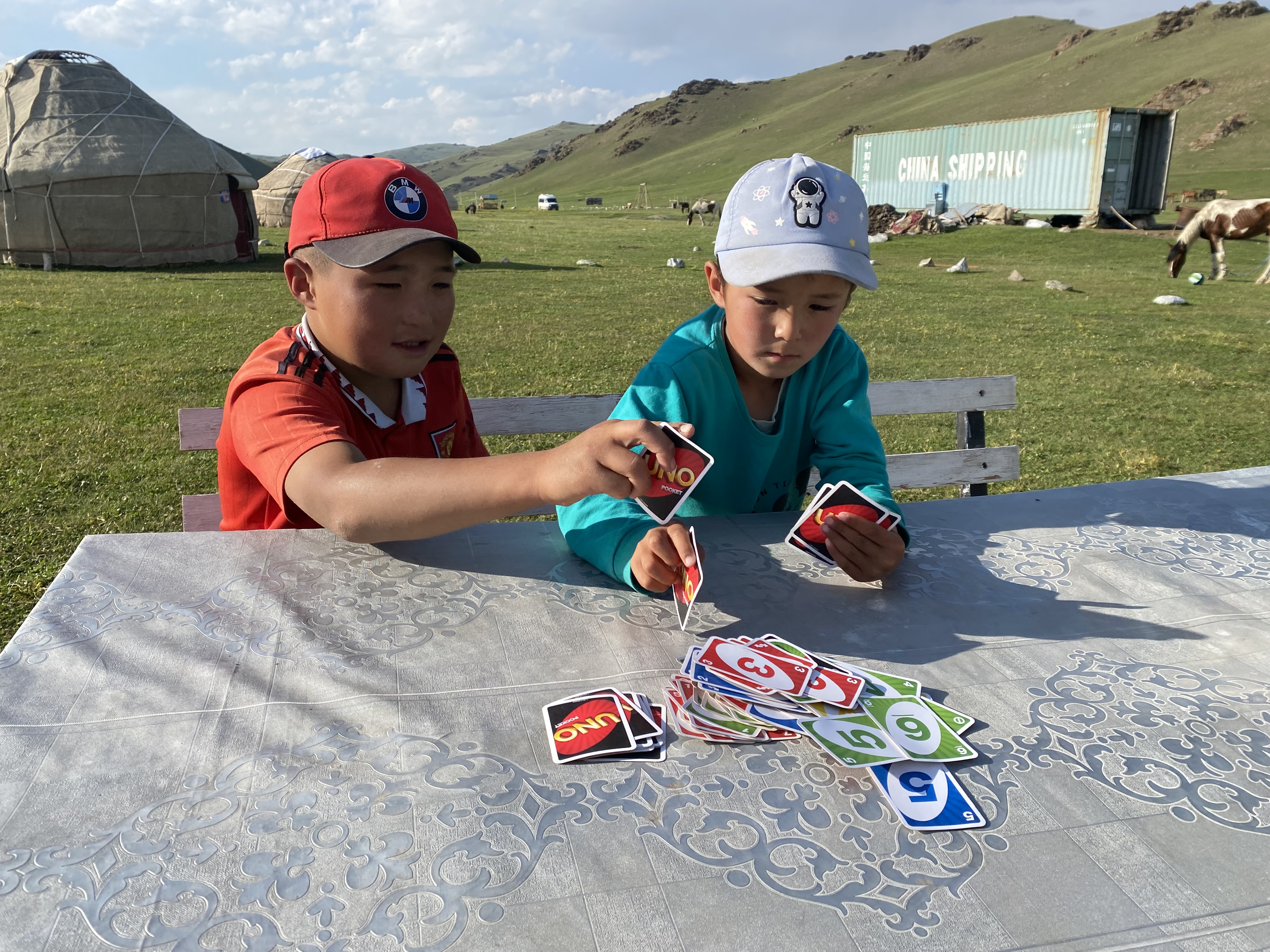 Two Kyrgyz kids playing a game of Uno.