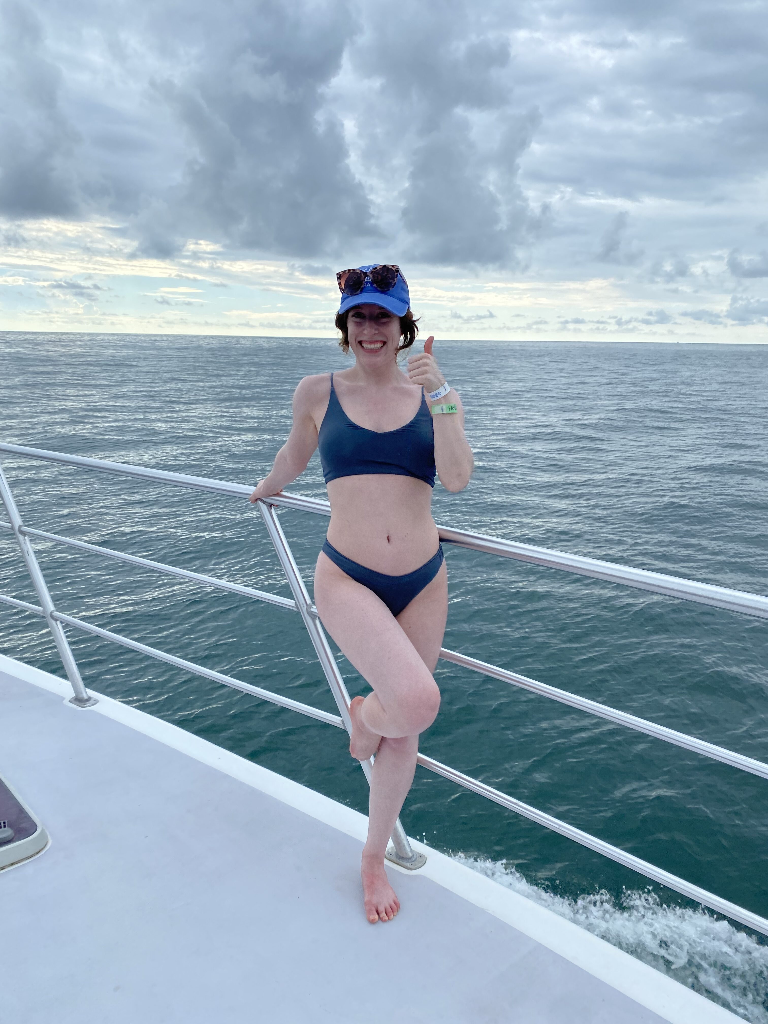 Bella poses in a bikini with a thumbs-up on the deck of a catamaran in Costa Rica.
