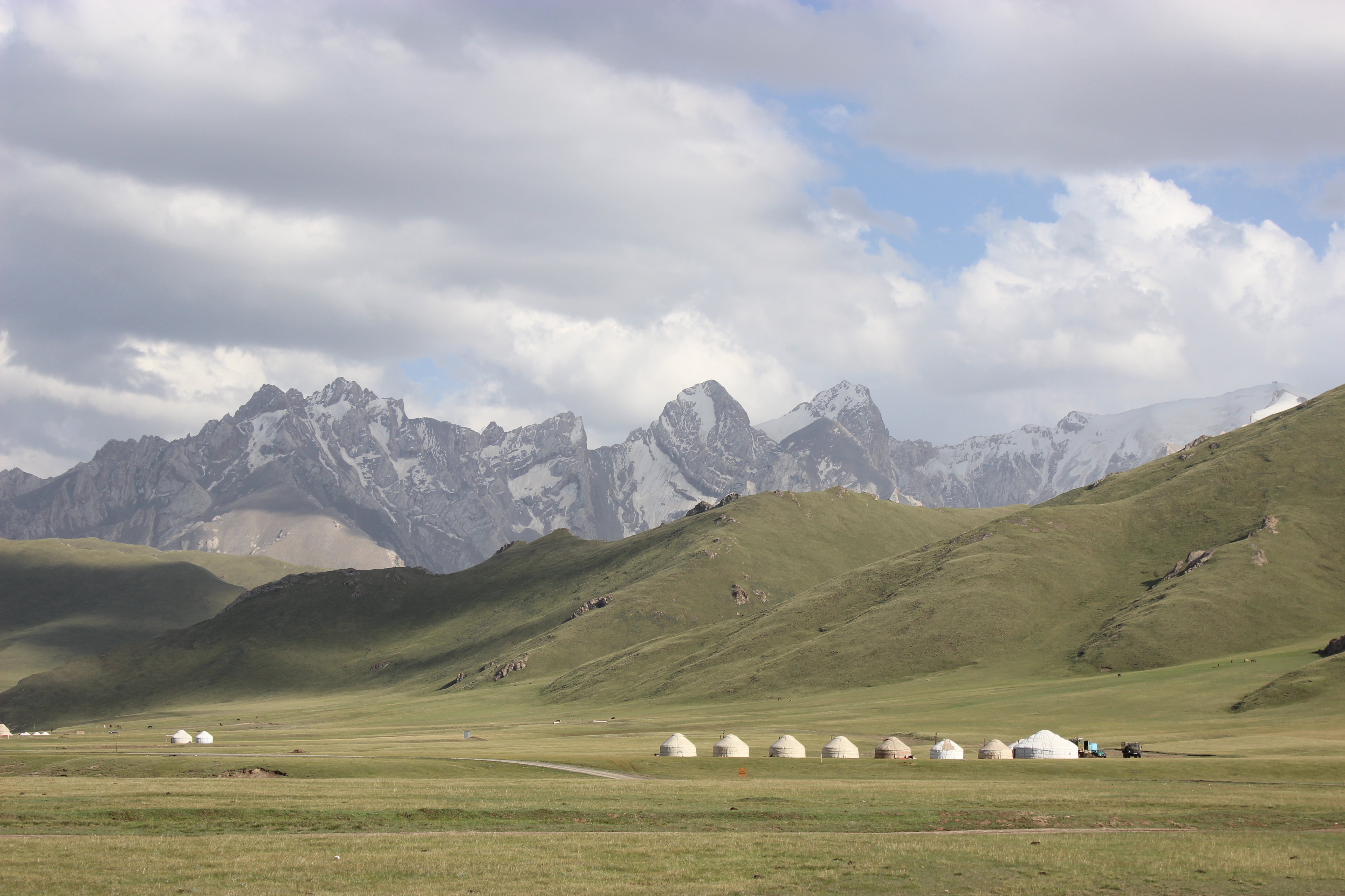A yurt camp in the Kok Kiya valley with beautiful jagged mountains in the background.