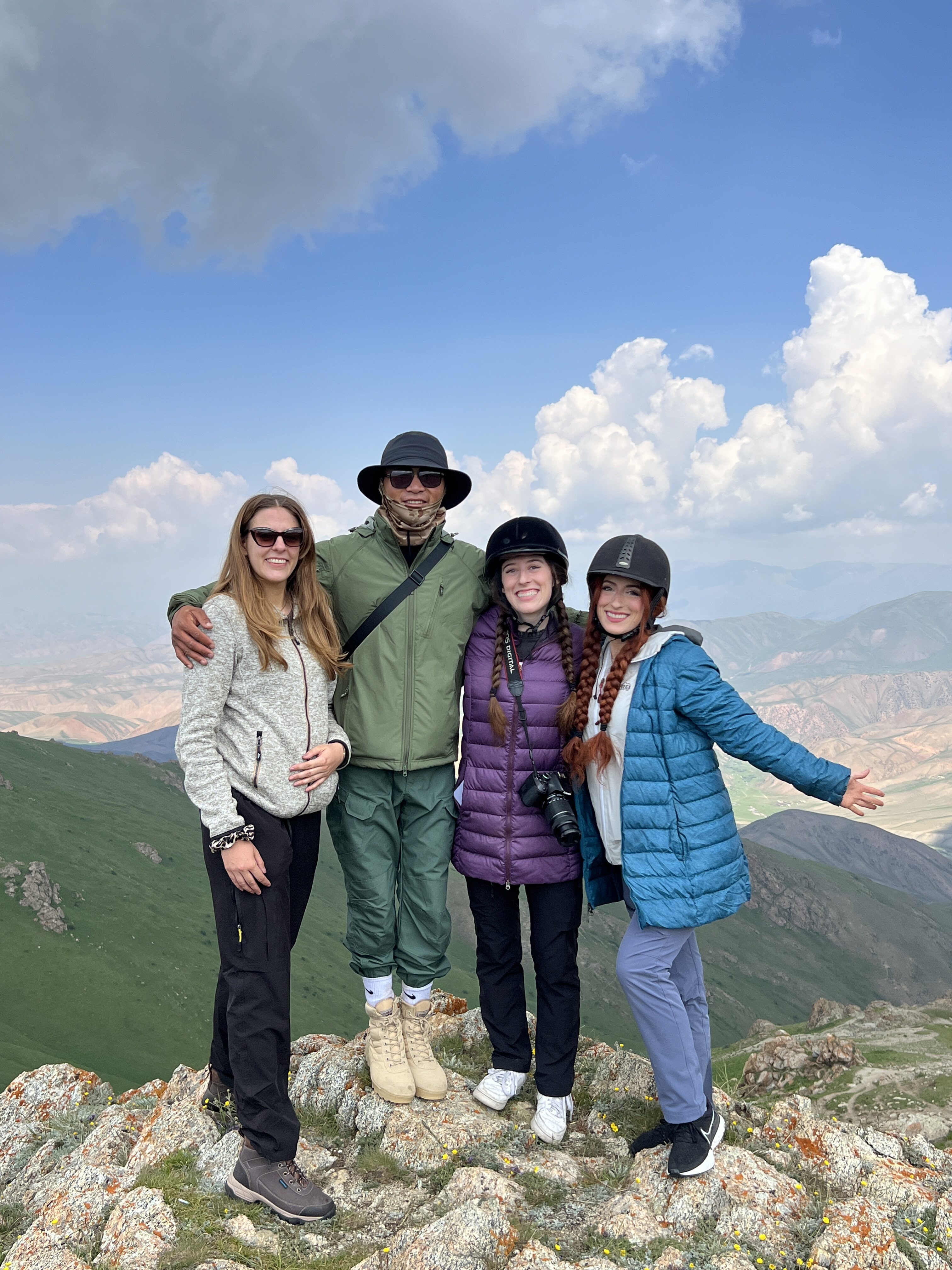 Lena, Medet, Bella and Lily smiling at the top of Jalgyz-Karagay Pass outside of Song Kul.
