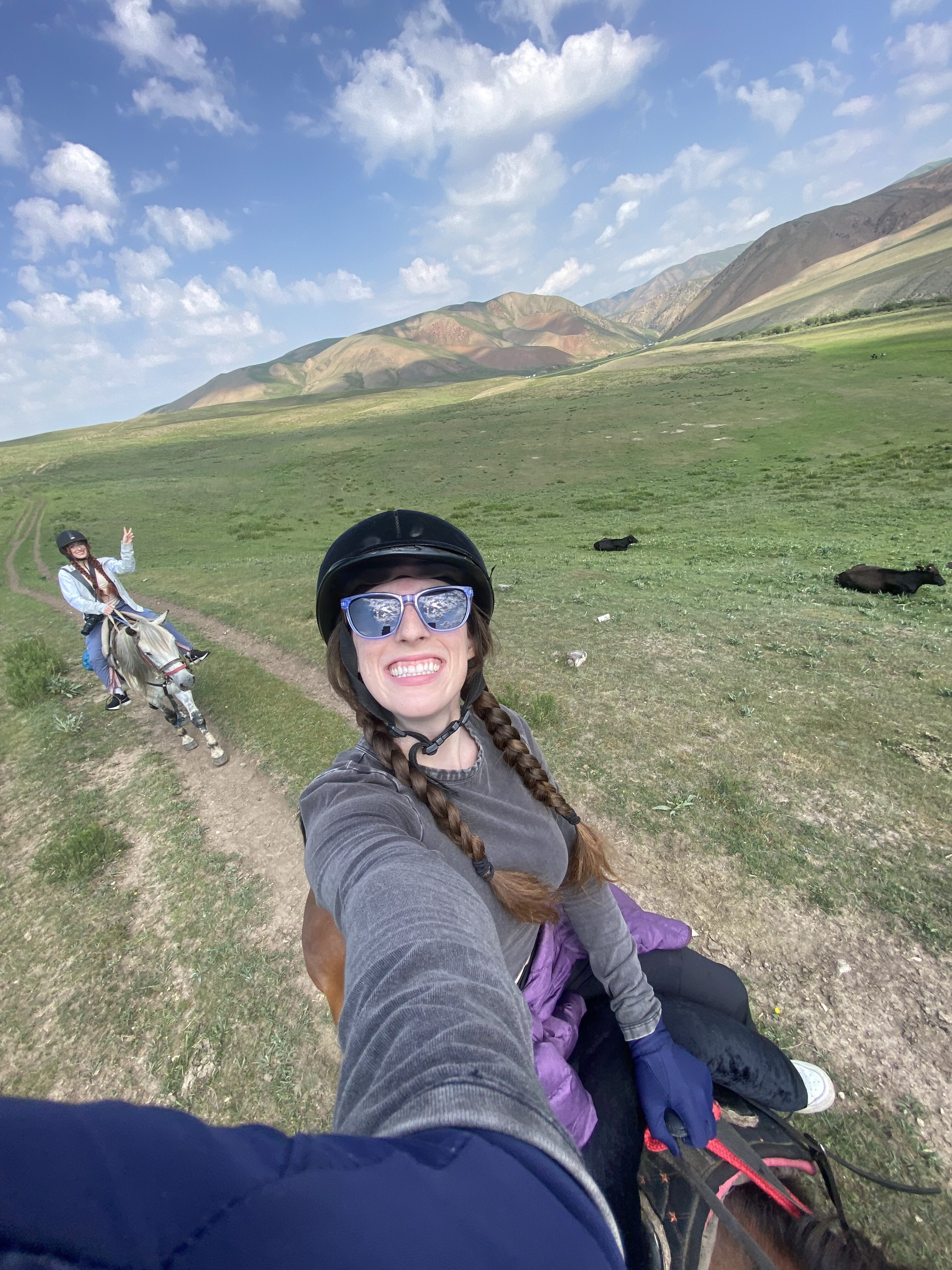 Bella taking a selfie on horseback with Lily in the background.