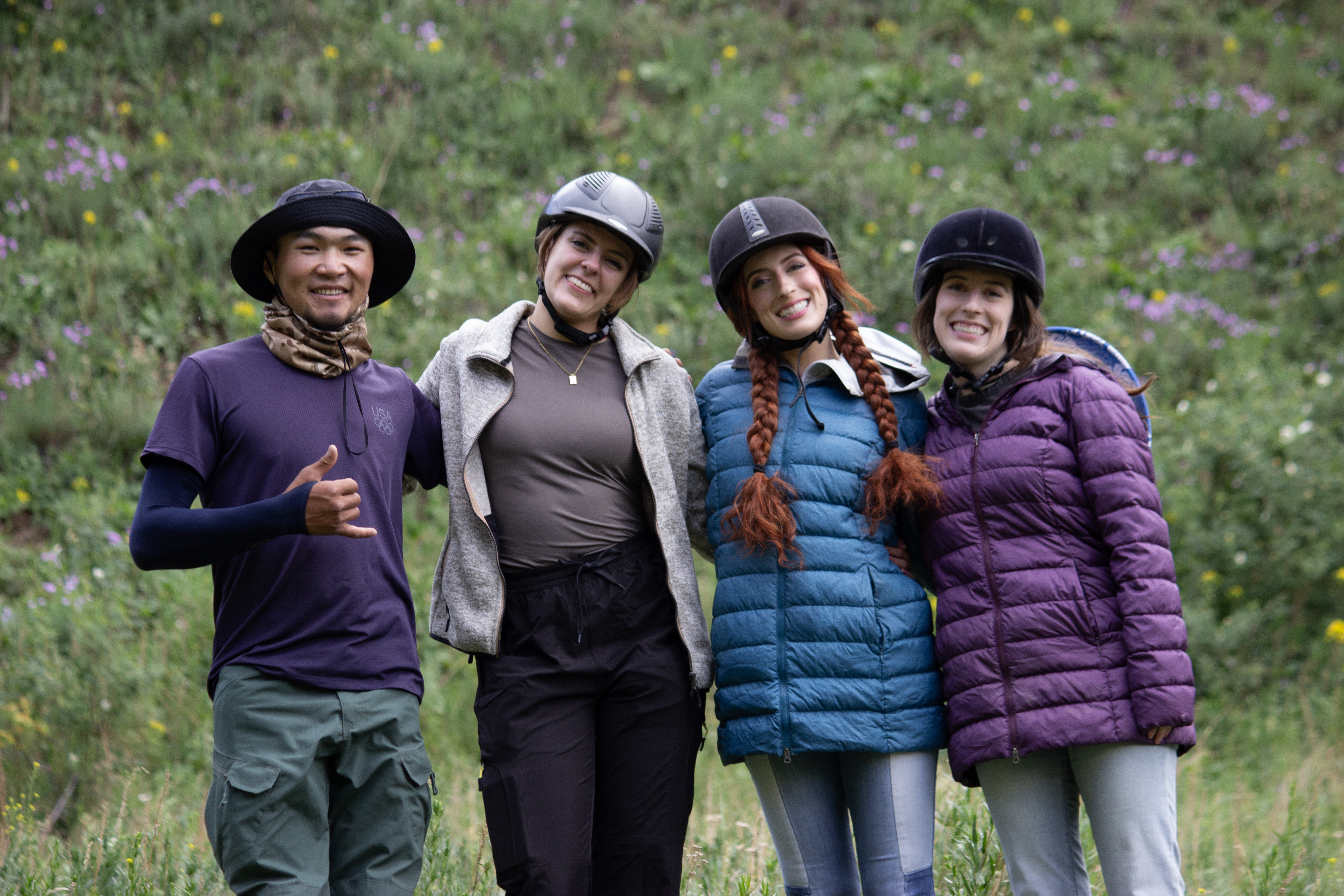 Medet, a local Kyrgyz guide, Lena, Lily and Bella standing together for a group photo.