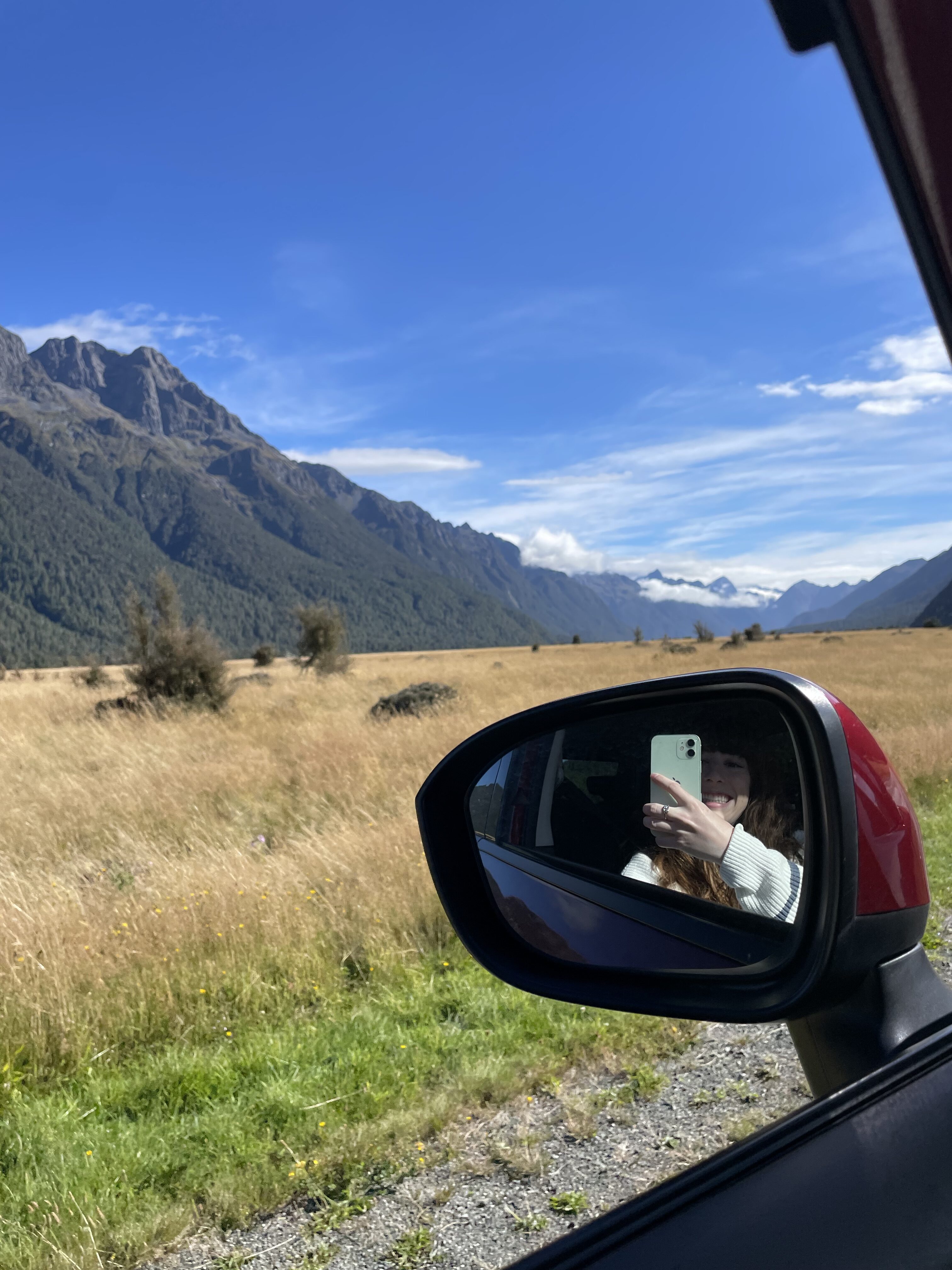 The picturesque Eglinton Valley – a famous Lord of the Rings filming location – with an imprint of the photographer with her iPhone is the car's side mirror.
