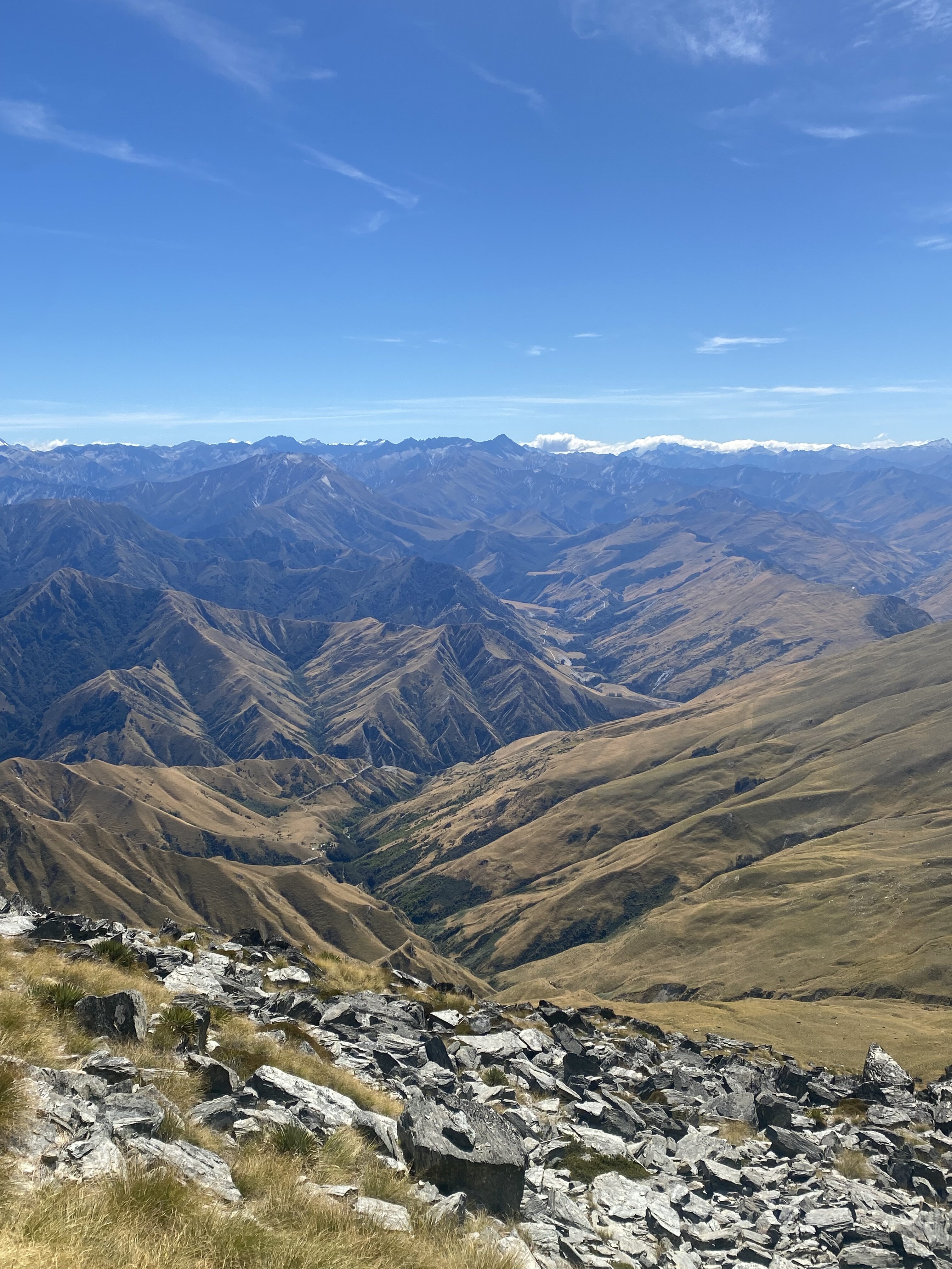 Scenic views along the Ben Lomond track showing a tan "blanket" of rippling mountains reach into the distance.