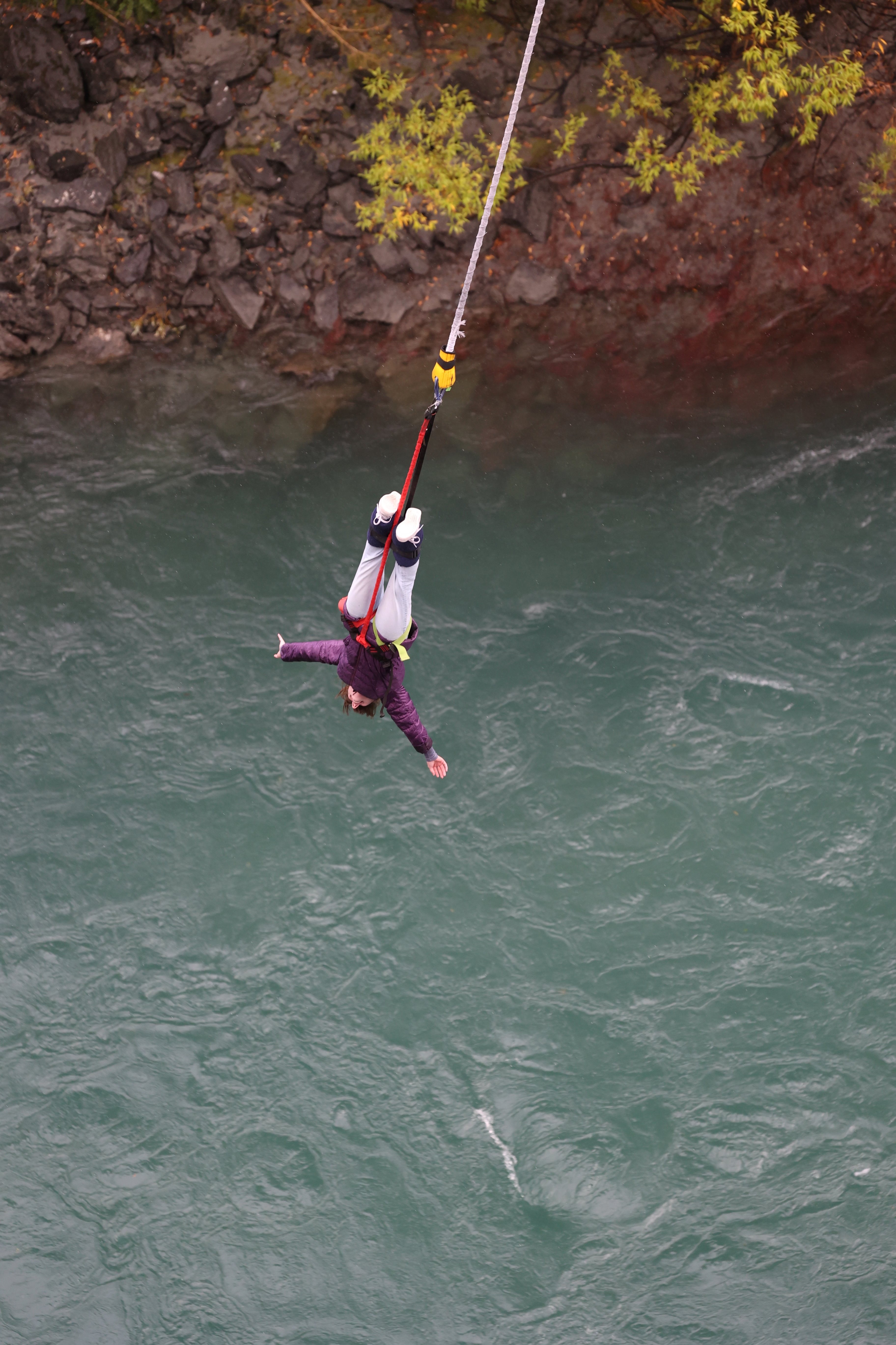 A bungee jumper In New Zealand suspended over the rushing Kawarau River.