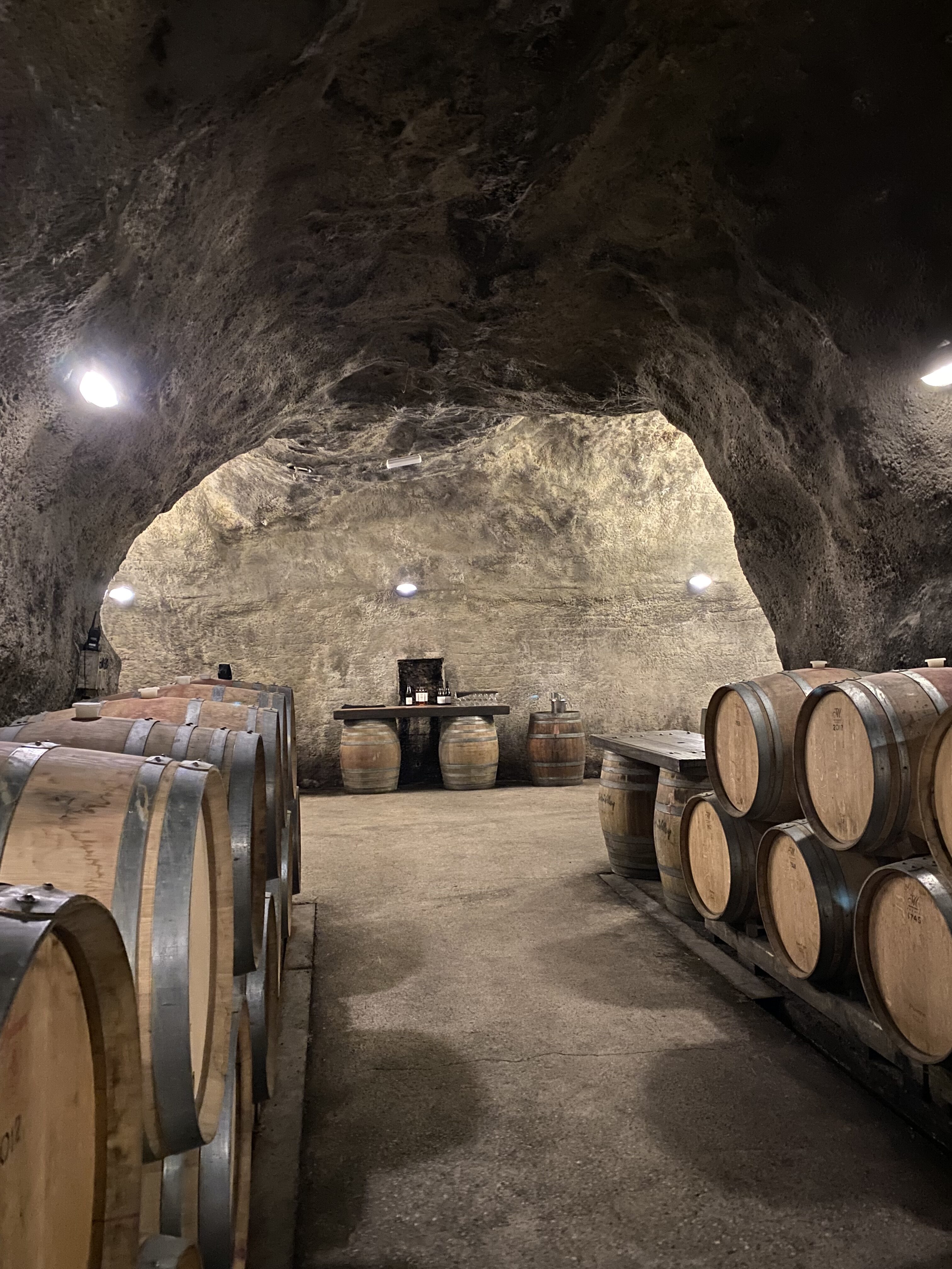 A collection of weathered wine barrels in a cave under Gibbston Valley Winery.