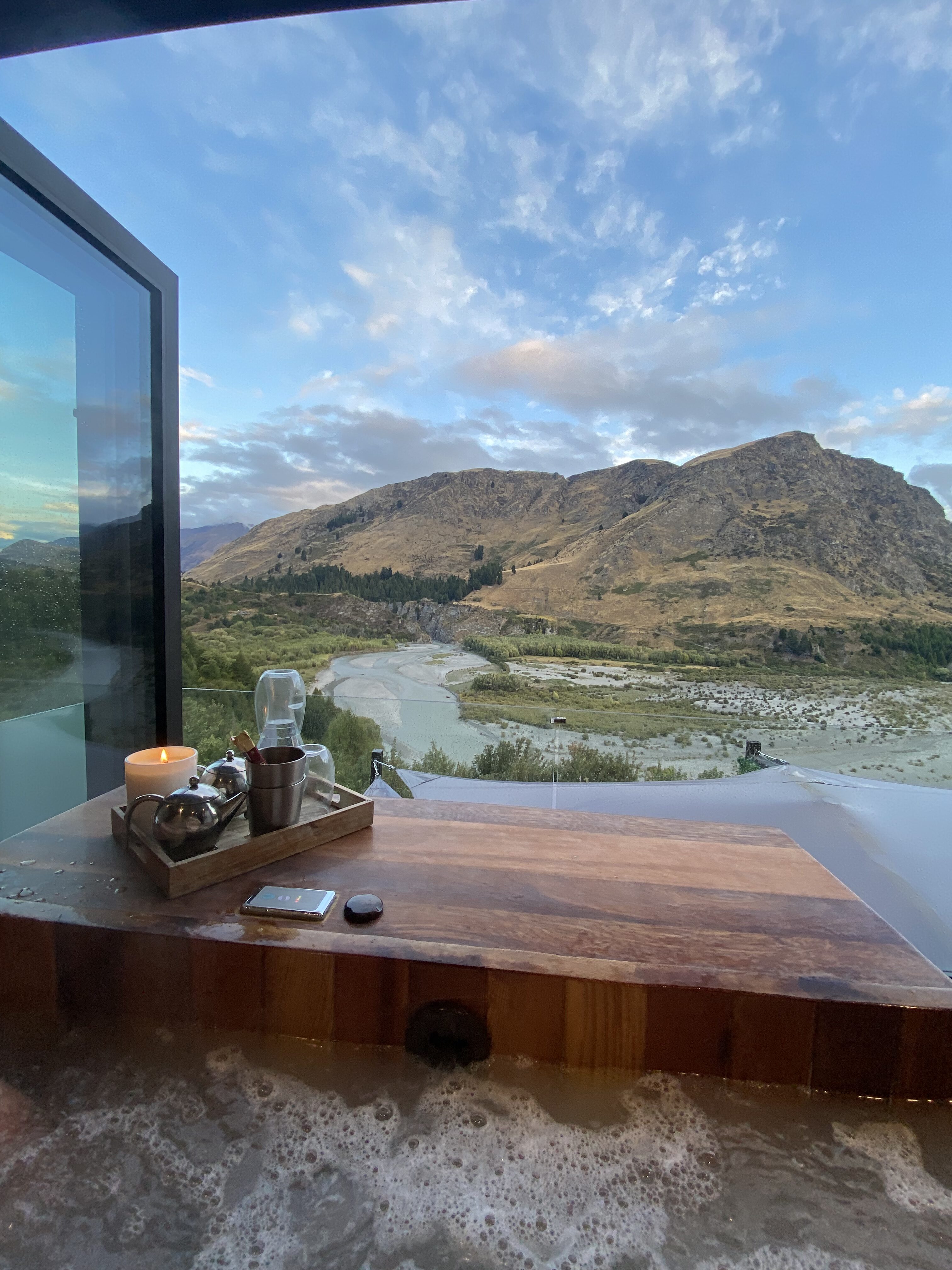 A relaxing, bubbly hut tub with a candle and tea pots overlooking the Shooter Canyon.