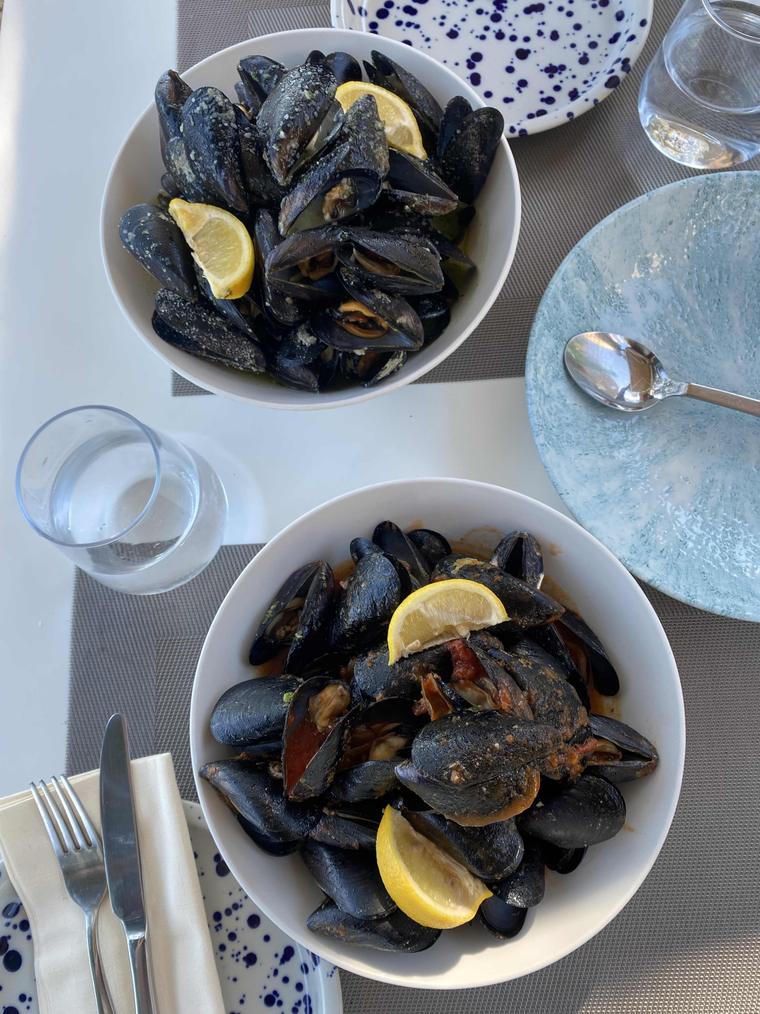 Bowls of fresh mussels with lemons and spices at a restaurant in Korčula Old Town.