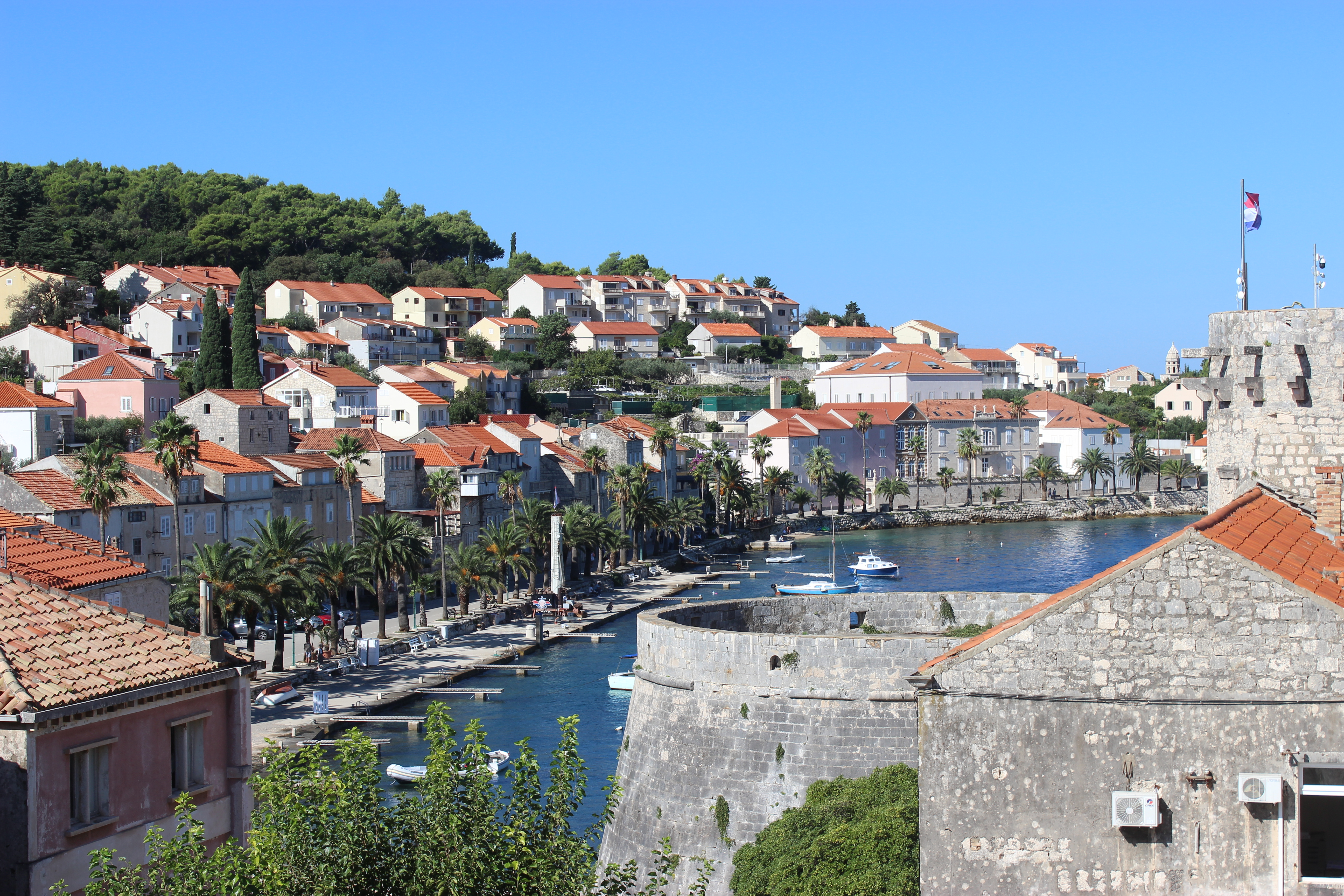 The orange roofs surrounding Korčula Old Town with the stone walls decorating the foreground.