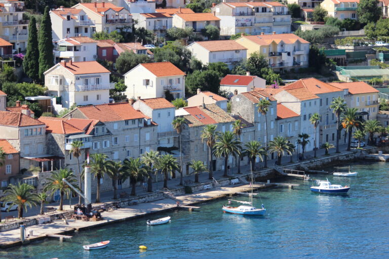 The beautiful island of Korčula with orange-roofed buildings built right along the harbor.