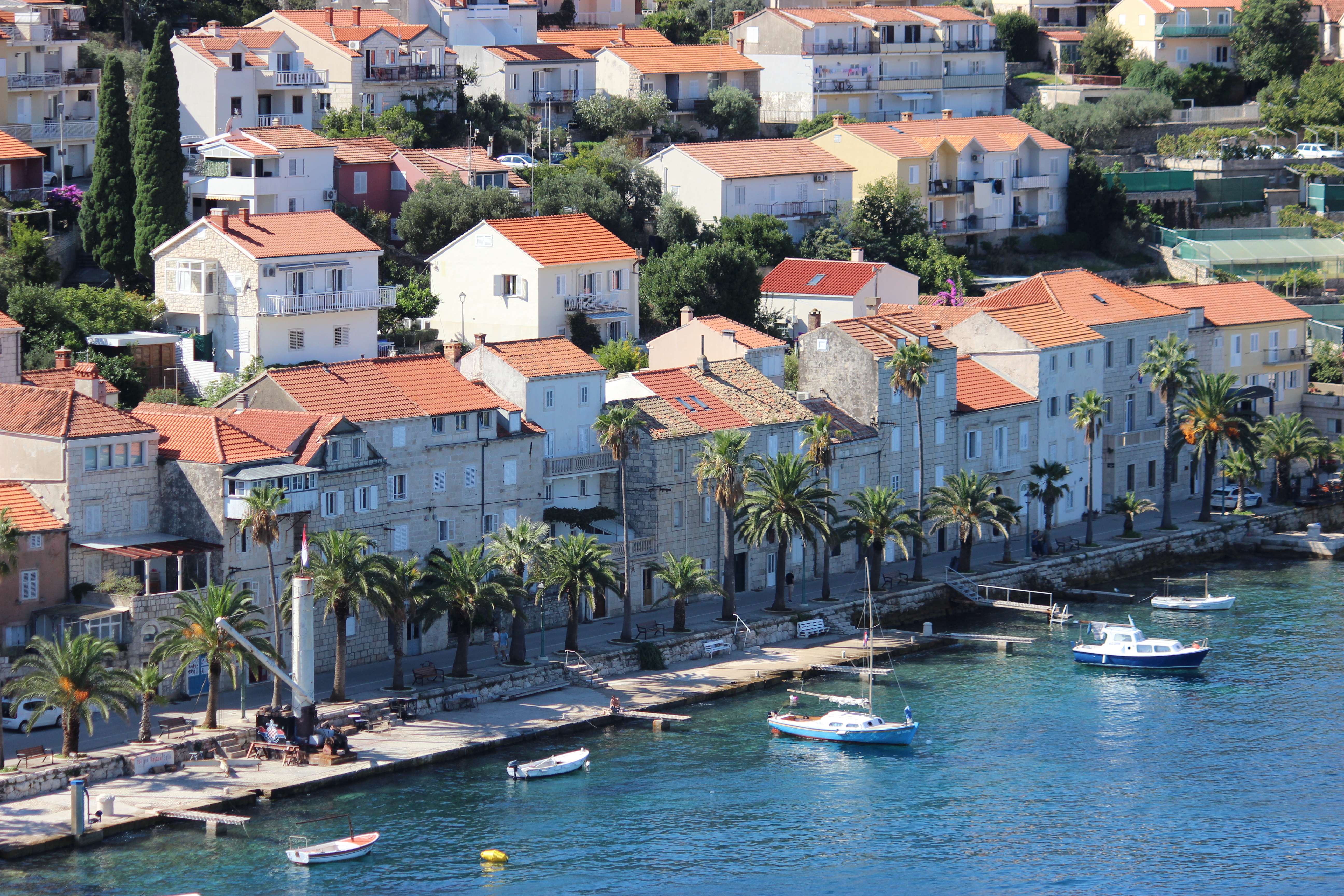 The beautiful island of Korčula with orange-roofed buildings built right along the harbor.