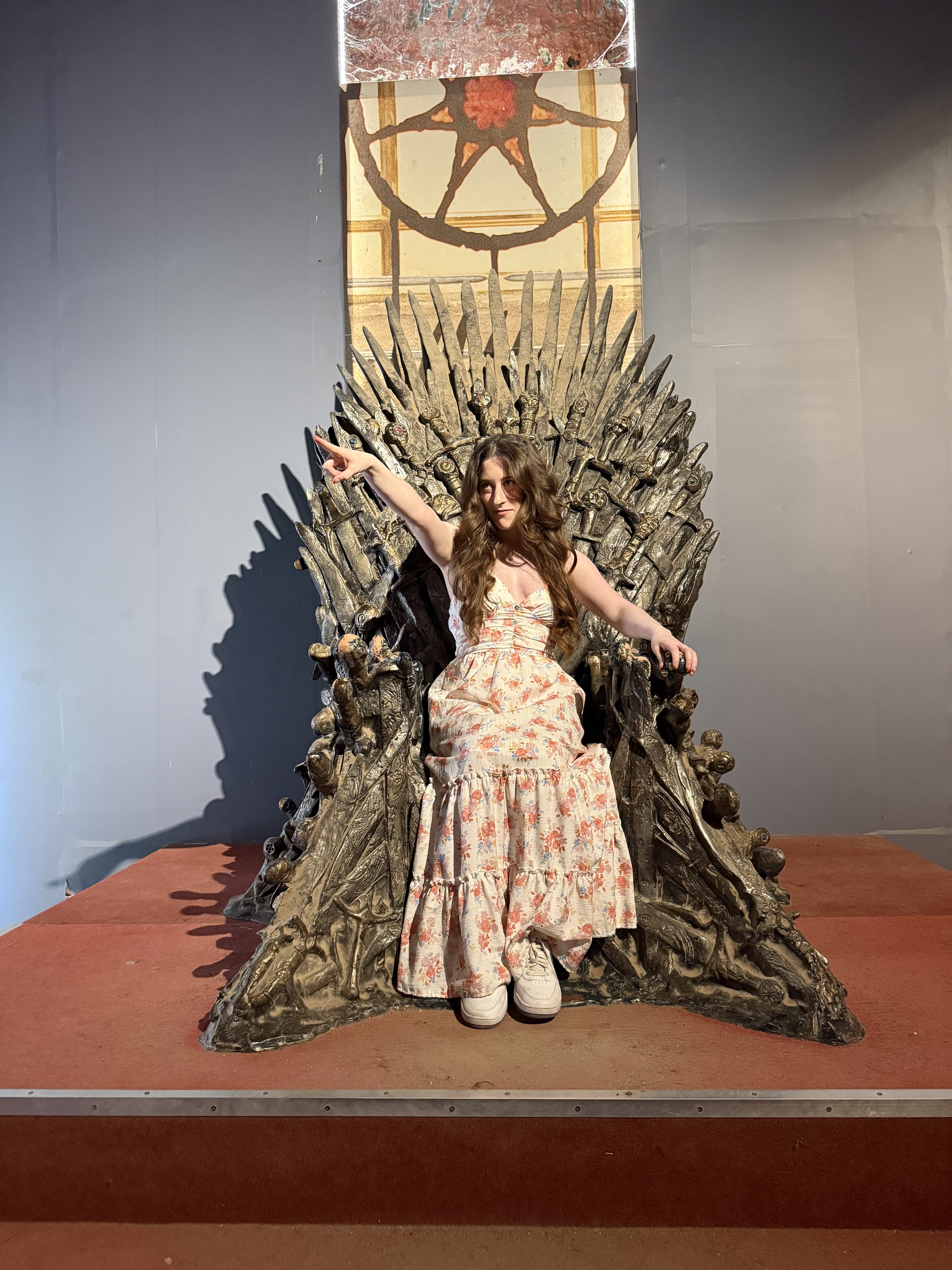 A young brunette woman sitting on the Iron Throne (Game of Thrones) in Lokrum Island.