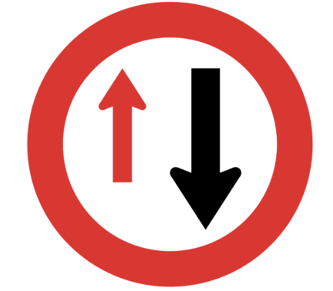 A bright red New Zealand road with two arrows, one small red pointing in one direction, and one large black pointing in the opposite direction (from commons.wikimedialorg)