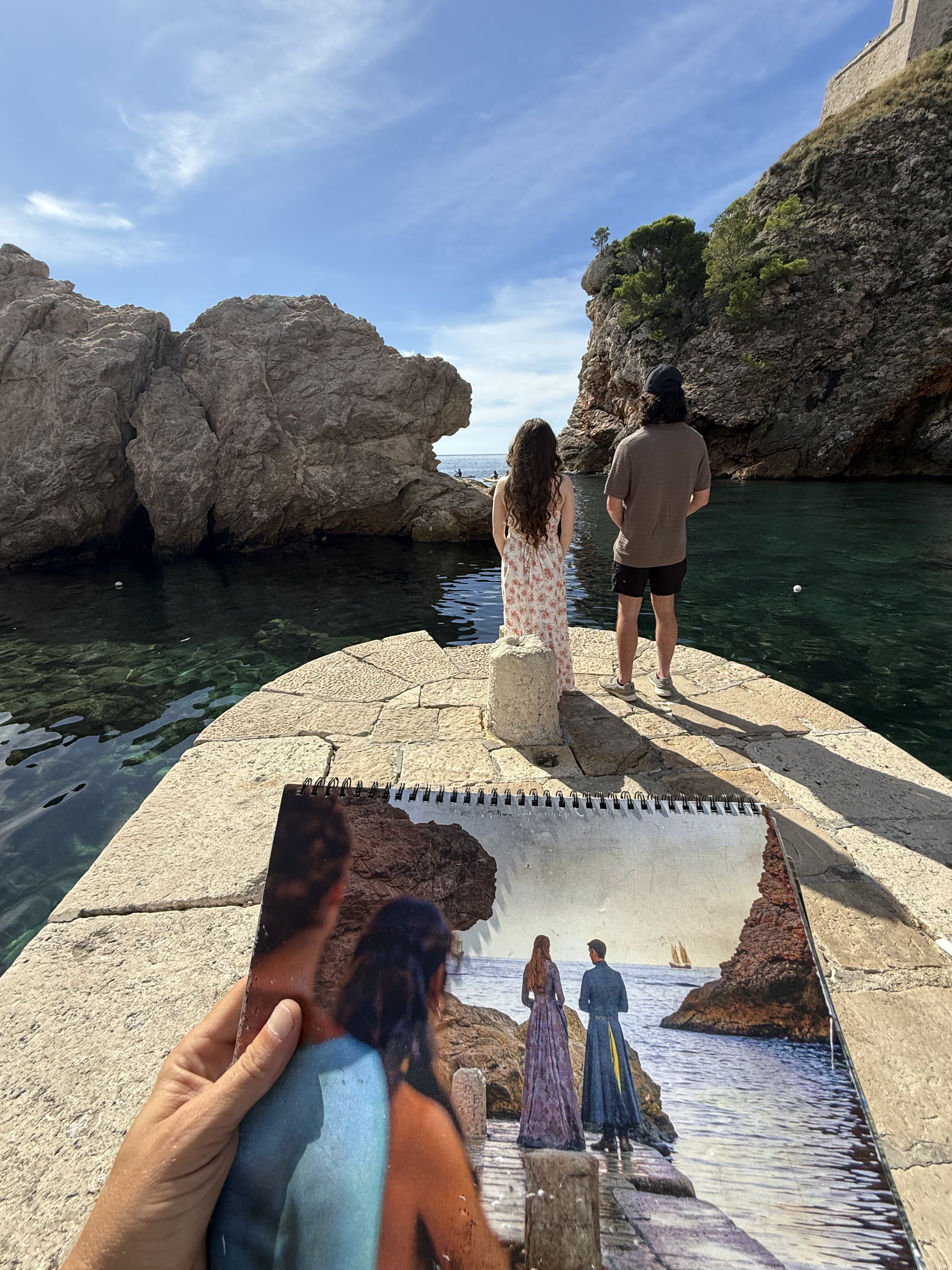 A picture of a Game of Thrones scene filmed at Dubrovnik West Harbor with a young couple re-enacting the scene.
