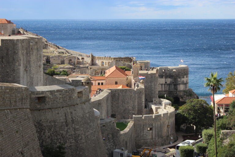 The Dubrovnik City Walls fortifying Old town with the blue Adriatic Sea in the background.