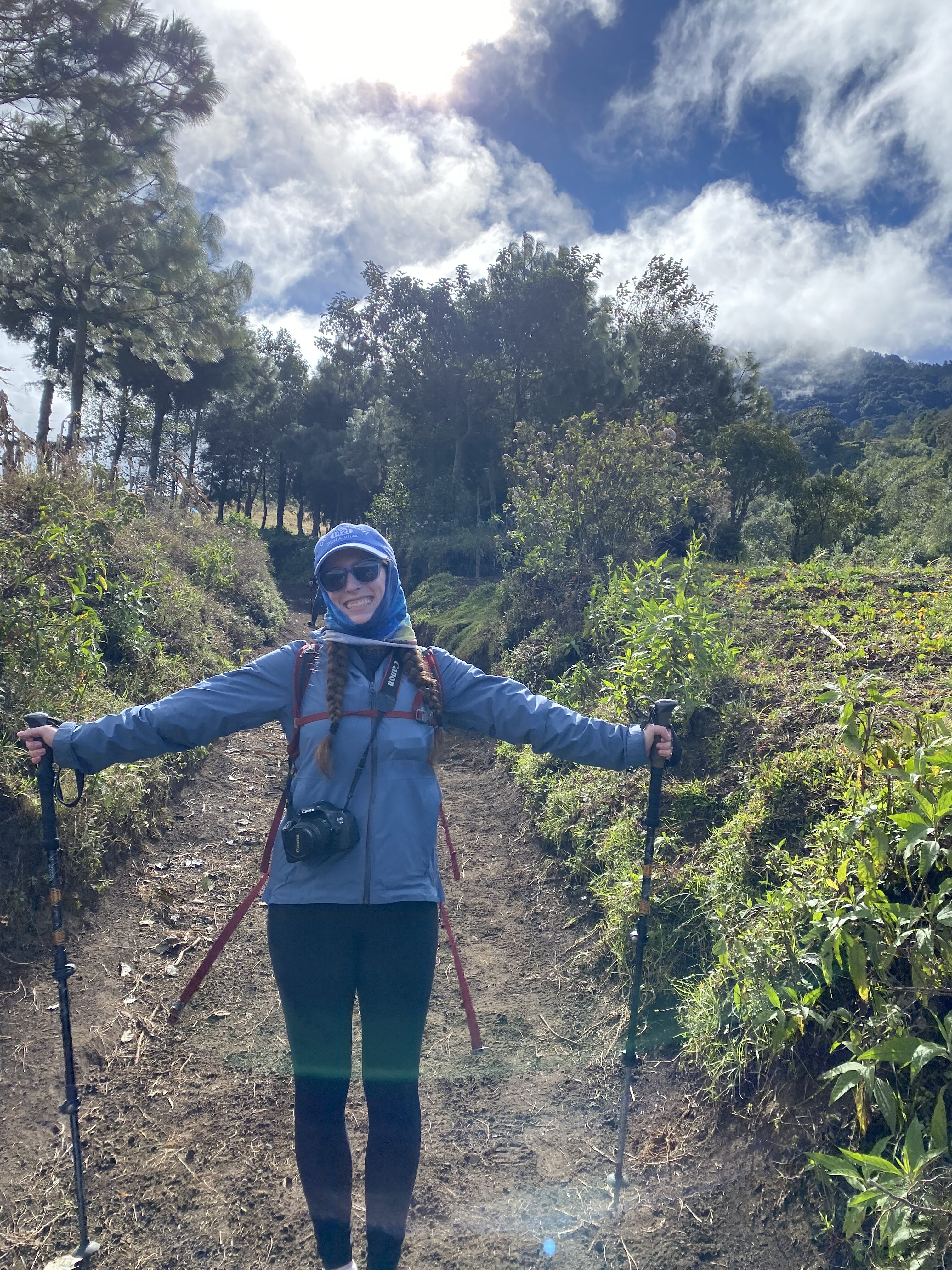 Bella posing with her arms wide at the start of the Acatenango hiking trail.