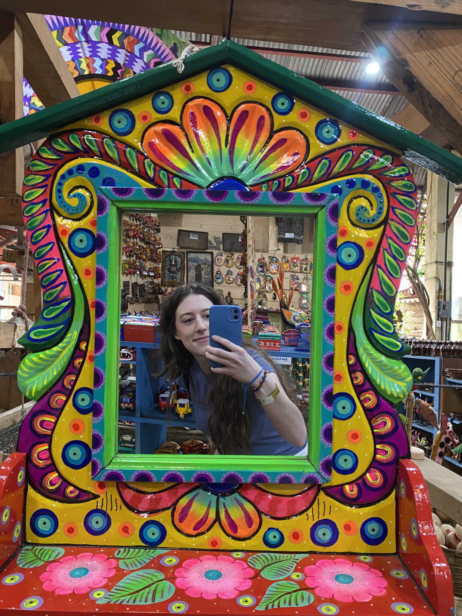 Bella taking a selfie in the colorful mirror in an art shop in Antigua, Guatemala.